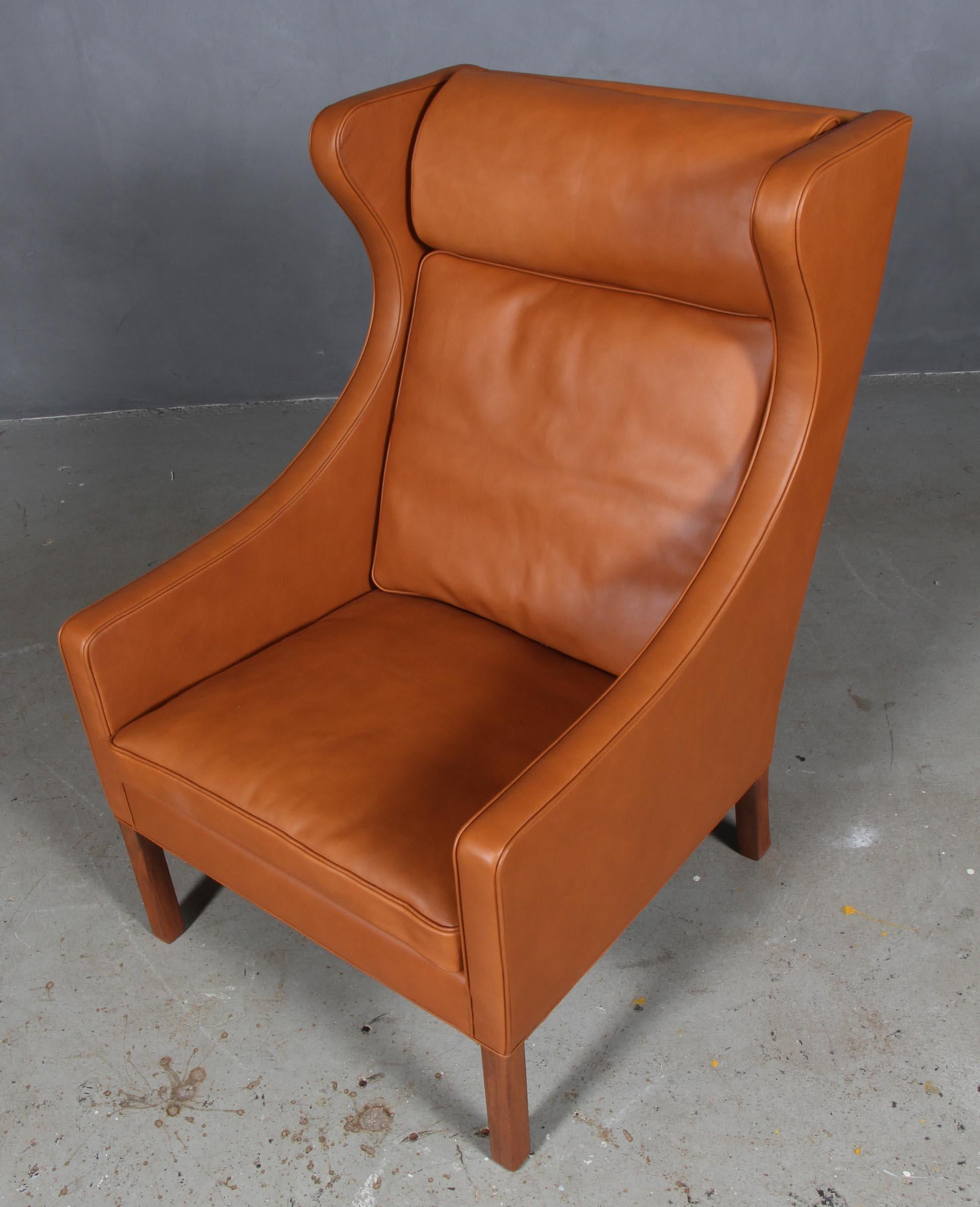 Chaise à oreilles Børge Mogensen nouvellement recouverte de cuir noyer élégant.

Pieds en teck.

Modèle 2204, fabriqué par Fredericia Furniture.