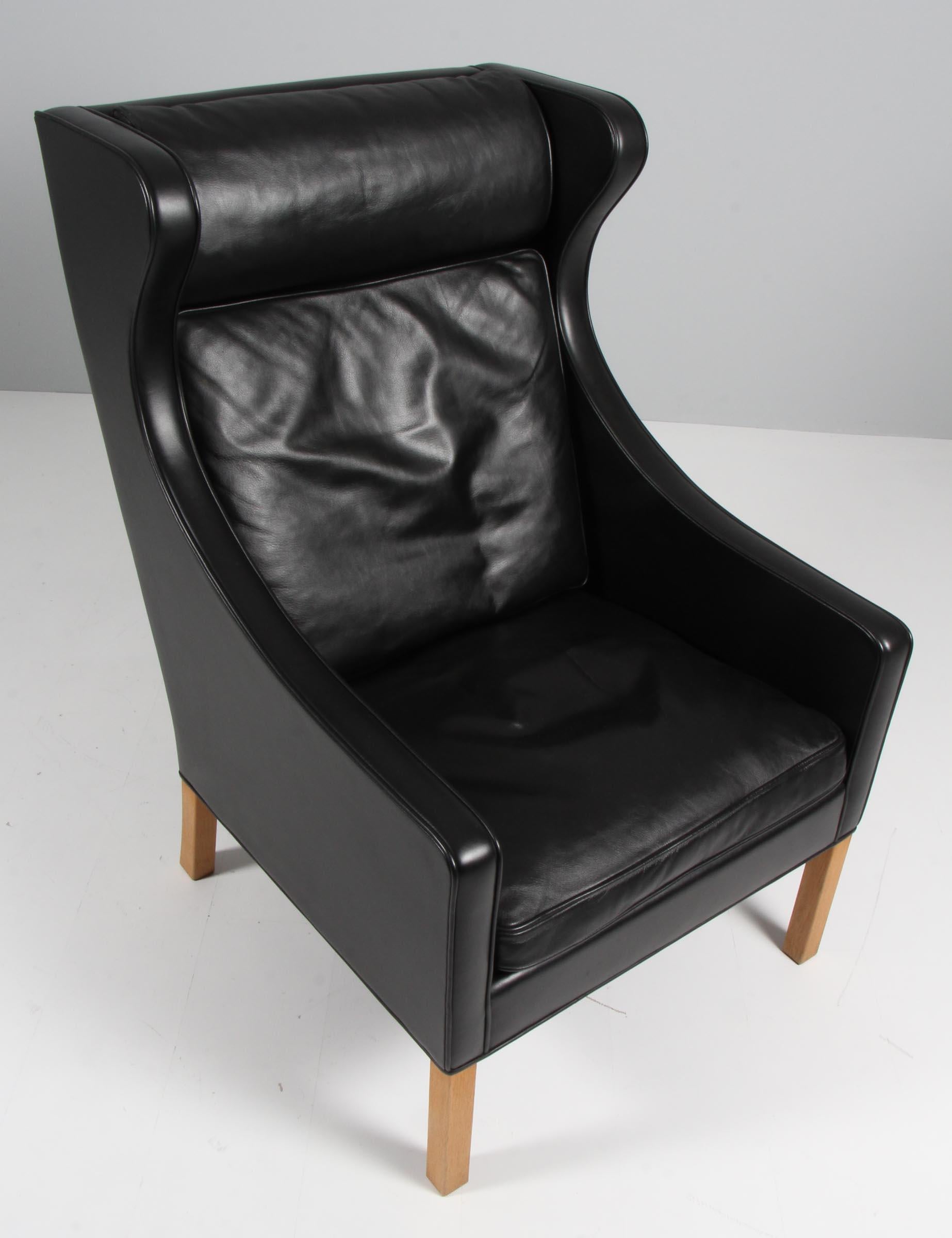 Børge Mogensen wingback chair in original Black leather upholstery.

Legs in oak.

Model 2204, made by Fredericia Furniture.