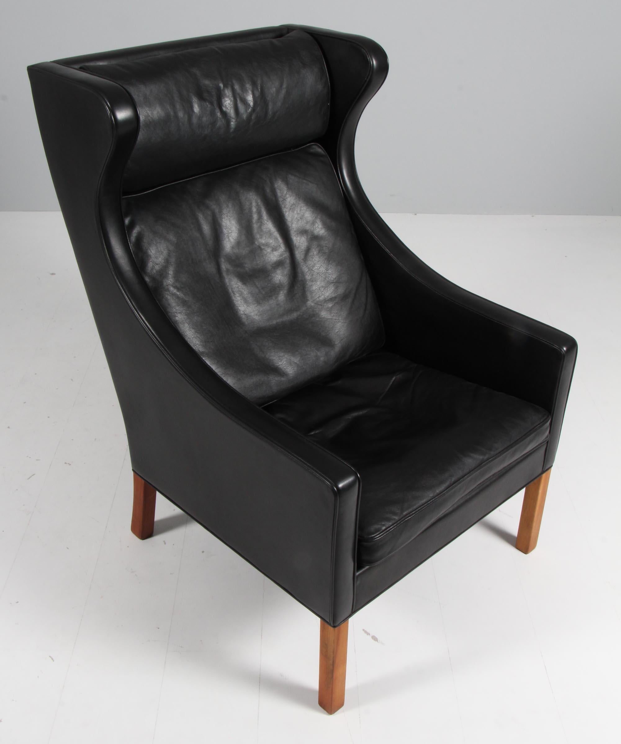 Børge Mogensen wingback chair in original Black leather upholstery.

Legs in teak.

Model 2204, made by Fredericia Furniture.