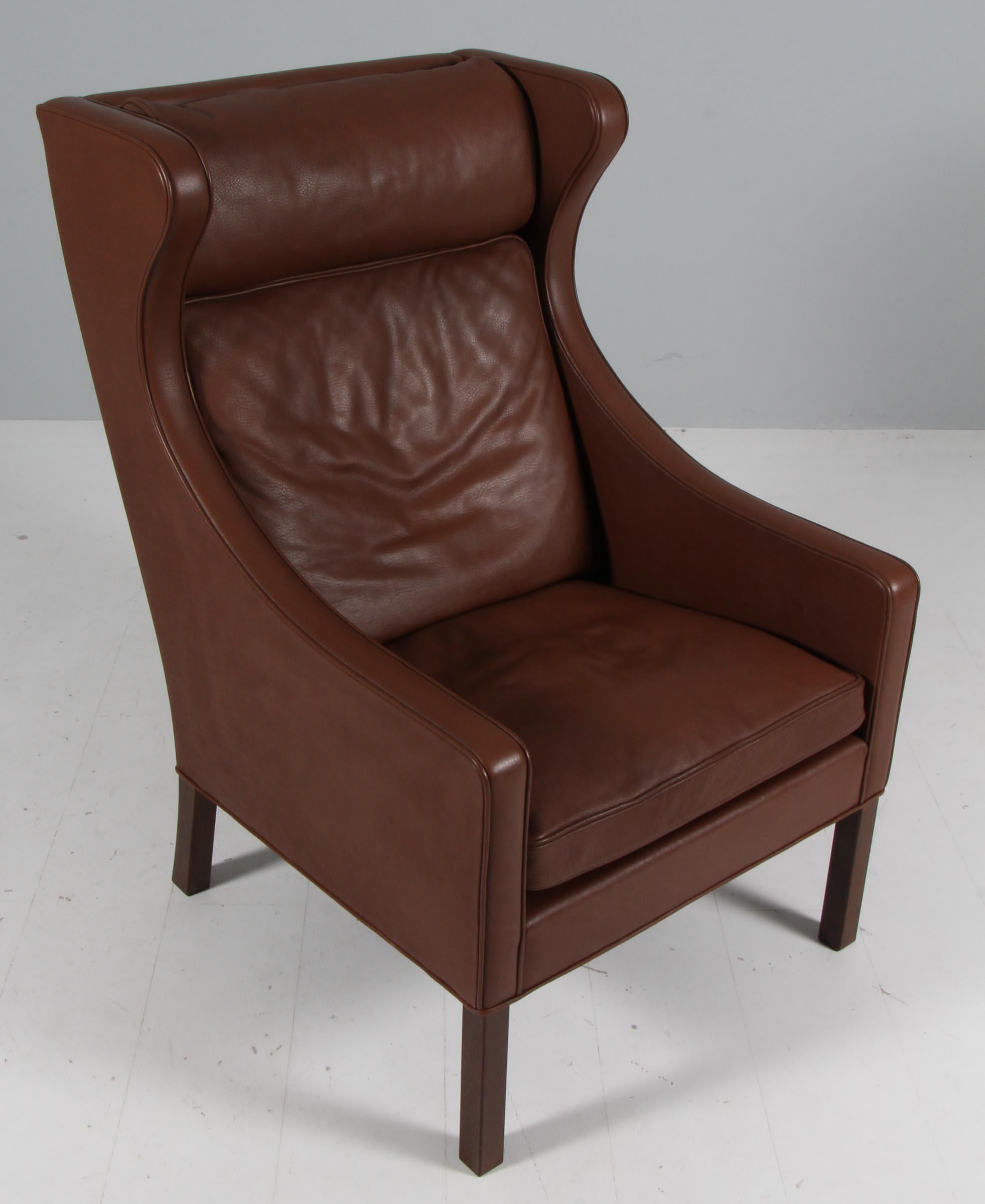 Børge Mogensen wingback chair in original brown leather upholstery.

Legs in stained oak.

Model 2204, made by Fredericia Furniture.