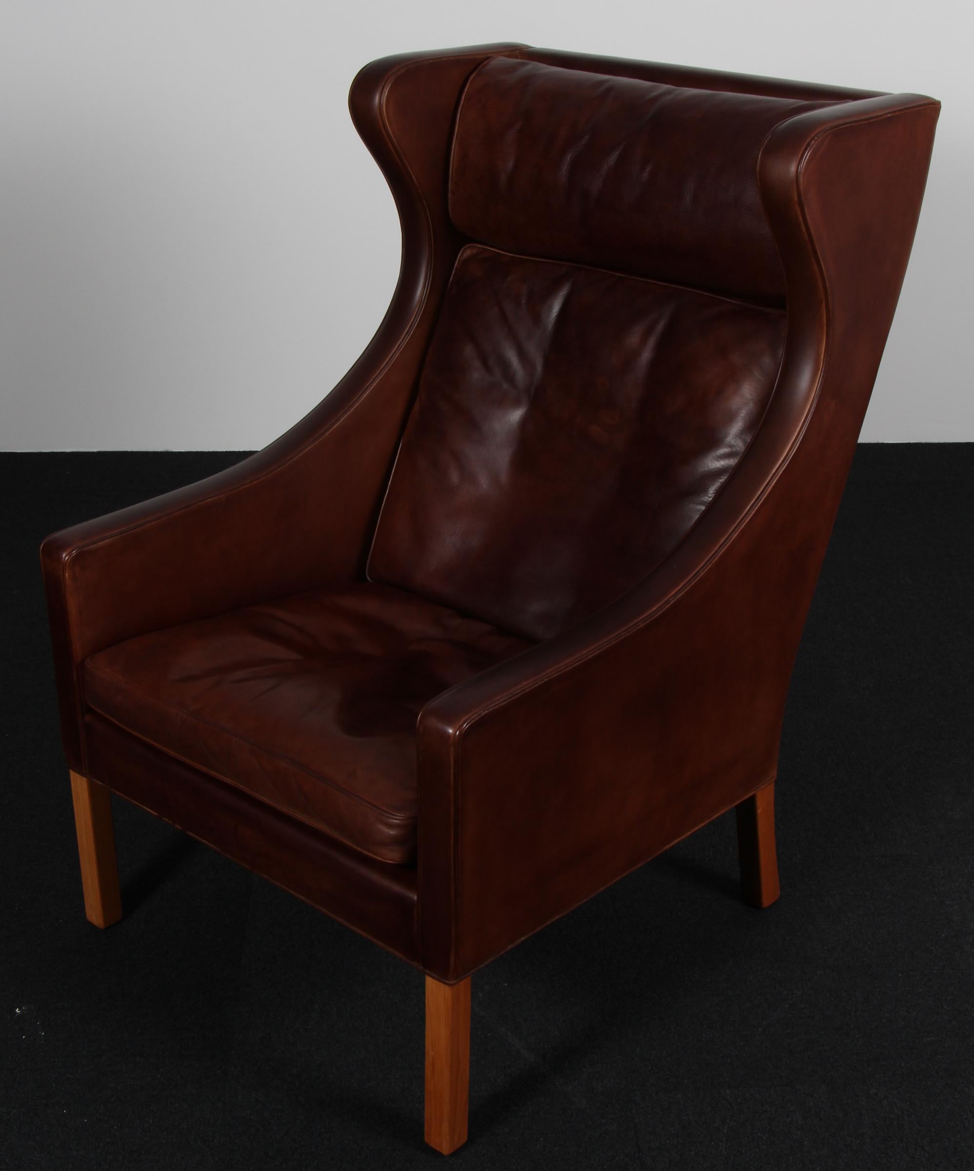 Fauteuil à oreilles Børge Mogensen en cuir nature patiné d'origine.

Pieds en teck.

Modèle 2204, fabriqué par Fredericia Furniture.