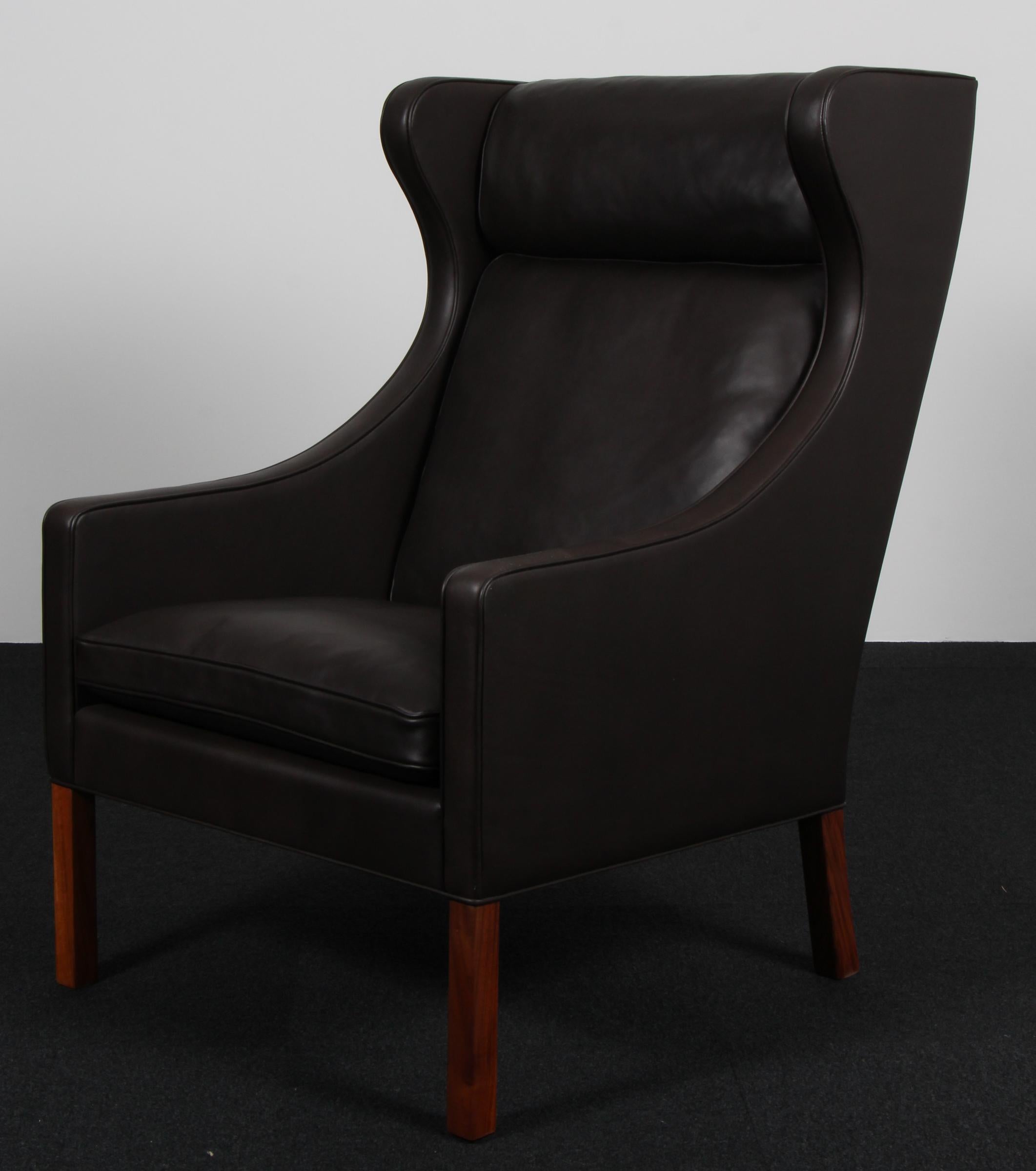 Sedia wingback Børge Mogensen nuova, rivestita in pelle mokka elegance.

Gambe in teak.

Modello 2204, prodotto da Fredericia Furniture.