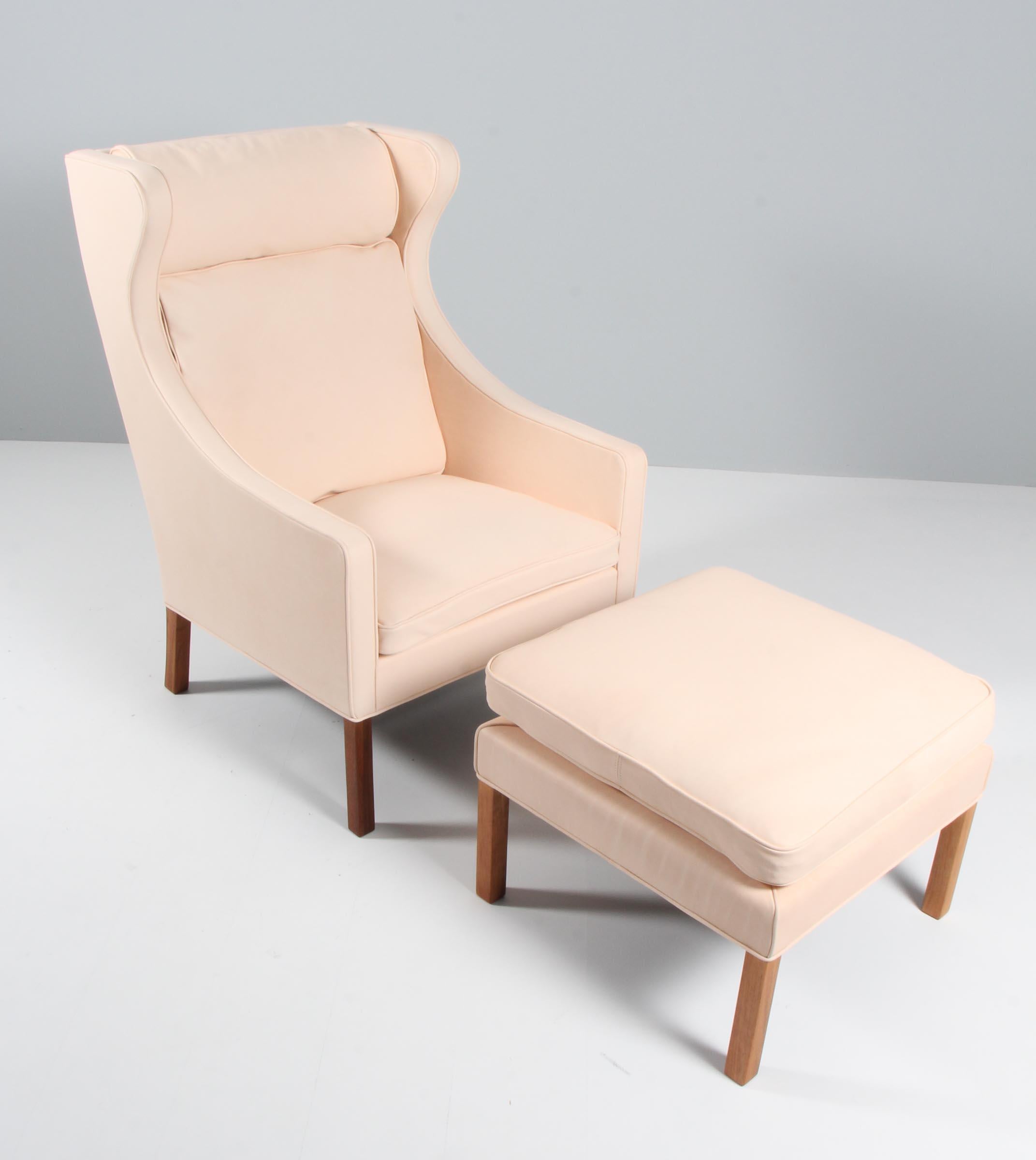 Chaise à oreilles Børge Mogensen avec ottoman nouvellement recouverte de cuir naturel végétal.

Pieds en teck.

Modèle 2204 + 2292, fabriqué par Fredericia Furniture.