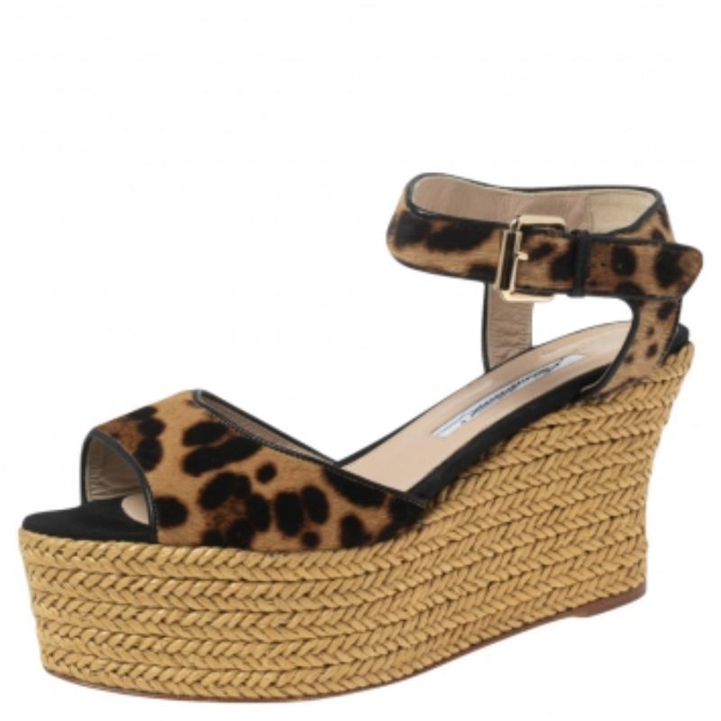 ¡Estas sandalias de la Casa de Brian Atwood son absolutamente preciosas! Están confeccionadas en pelo de poni beige-negro en el exterior y lucen tacones de cuña de alpargata, una correa en el tobillo y herrajes dorados. Estas sandalias son ideales