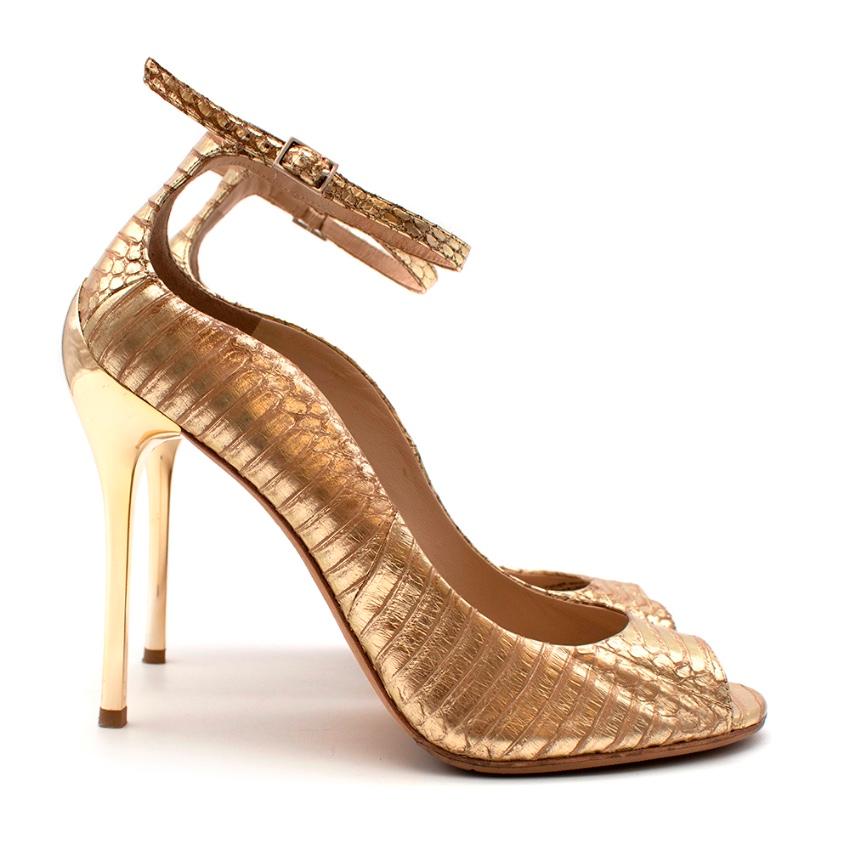 Brian Atwood Gold Snakeskin Embossed Open Toe Sandals

-Luxurious gold snakeskin 
-Sculptural golden heel 
-Peep toe design 
-Ankle strap with buckle fastening 
-Leather lining for comfort 

Materials:
Main- snakeskin 
Lining-leather 
Soles-leather