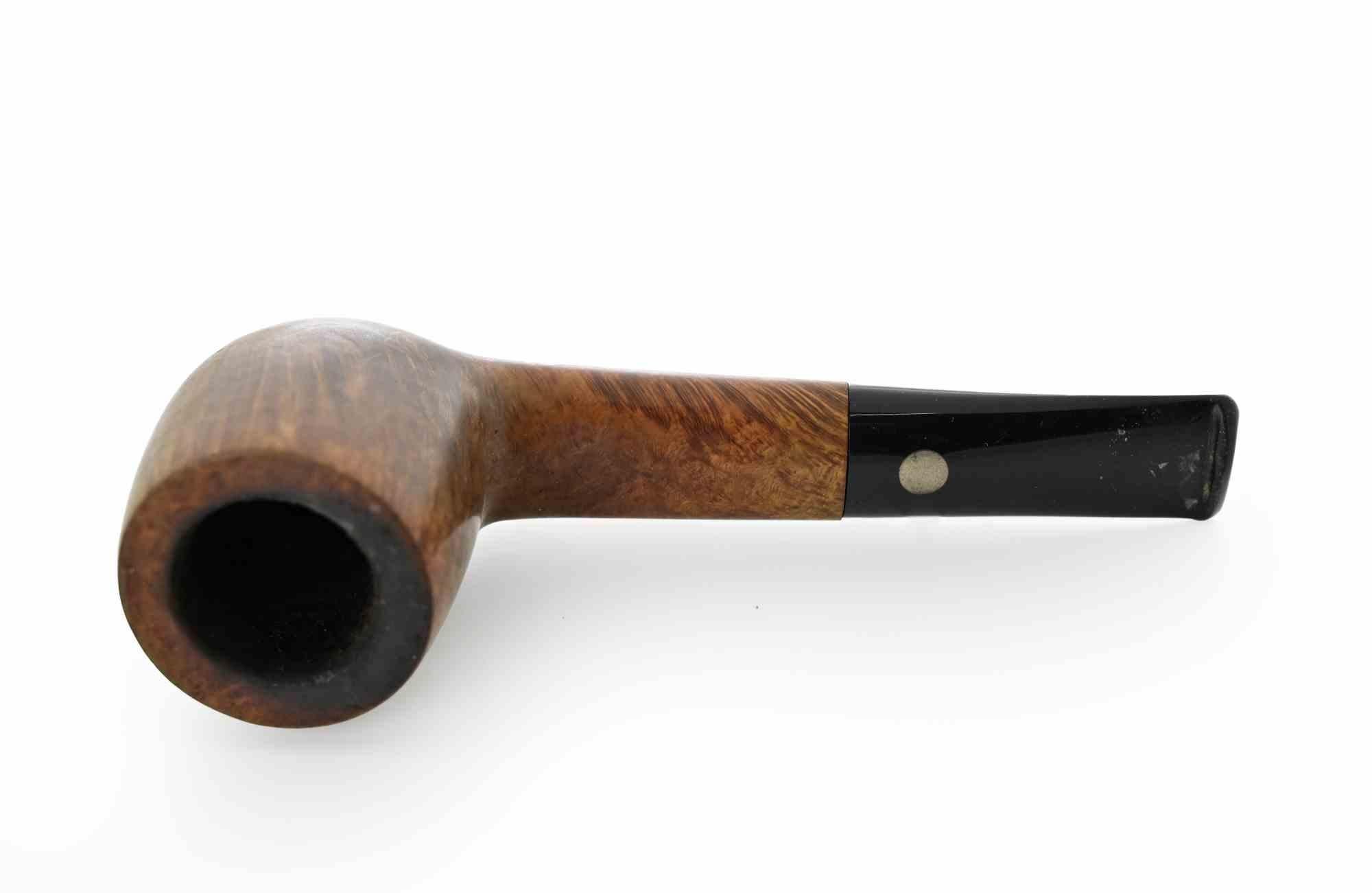 Une pipe à fumer finement fabriquée, d'une élégante simplicité, qui met en valeur les tons chauds et naturels du bois de bruyère. Le bol, avec sa finition lisse et ses subtils motifs en forme d'œil d'oiseau et de croix, porte les marques de l'âge et