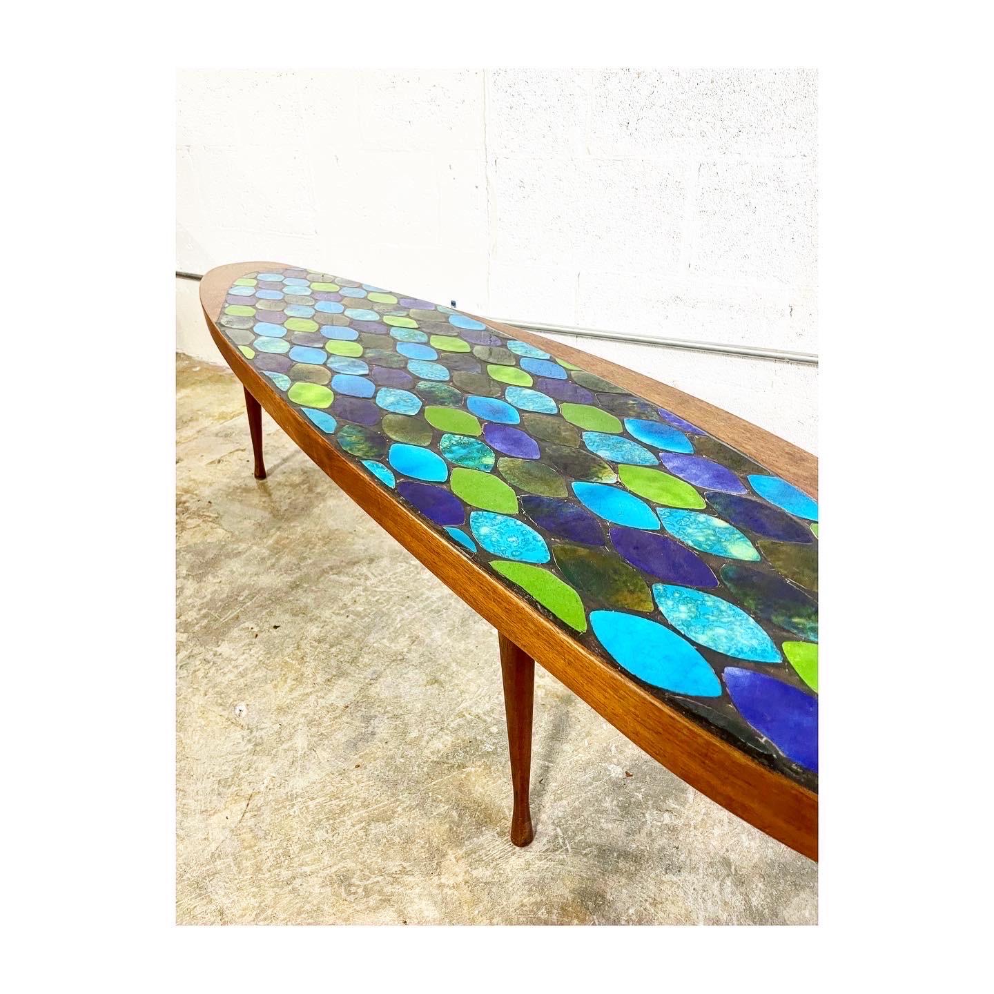 Stunning Mid-Century Modern coffee table. Ceramic Tile Inlaid. Surfboard shape. Vibrant blue and green colors.