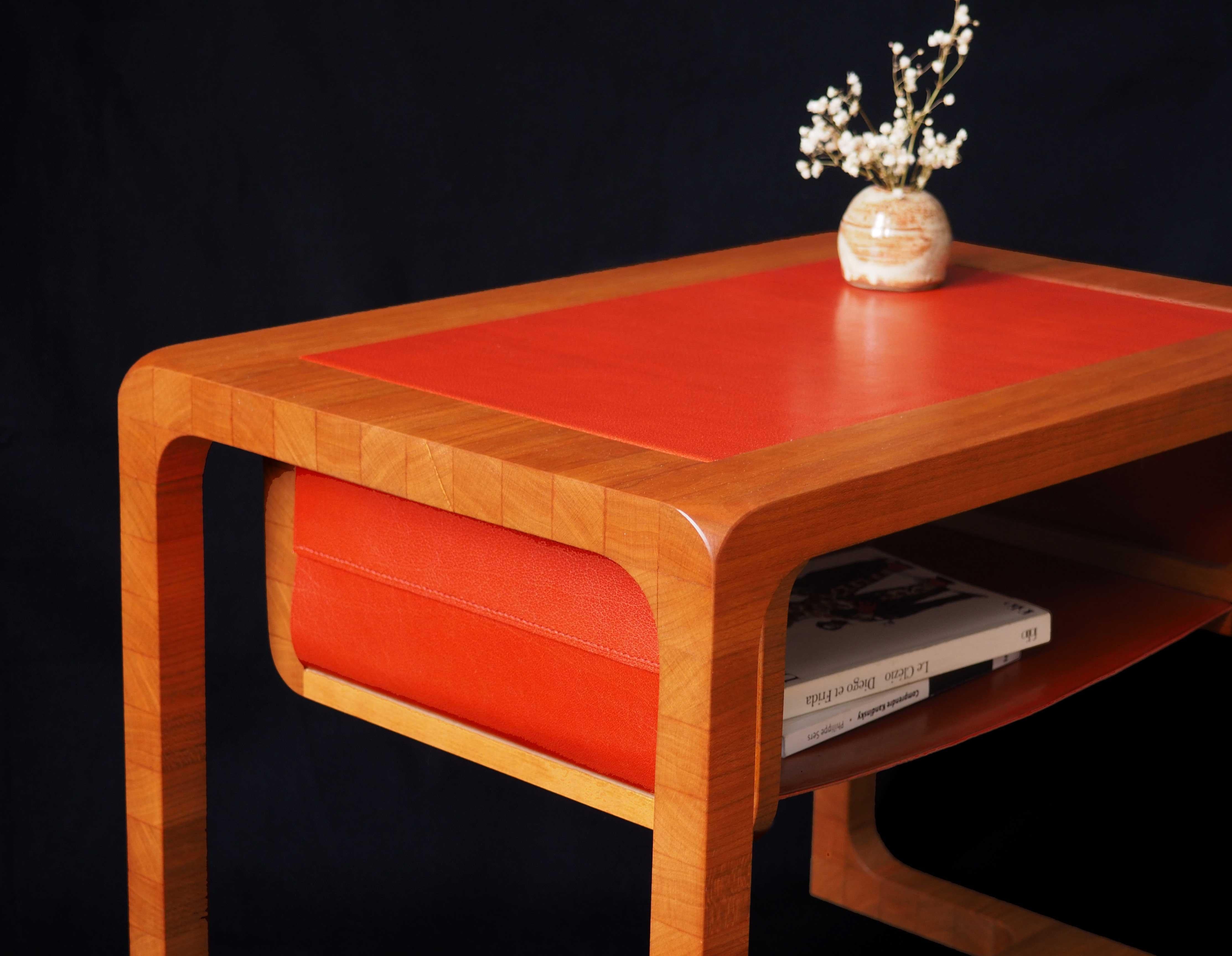 Side table made of massive cherry wood and orange vegetable-tanned leather.

This elegant piece of furniture made with end wood grain on his sides gives it an unique style. With its hanging storage compartment to accommodate books and magazines,