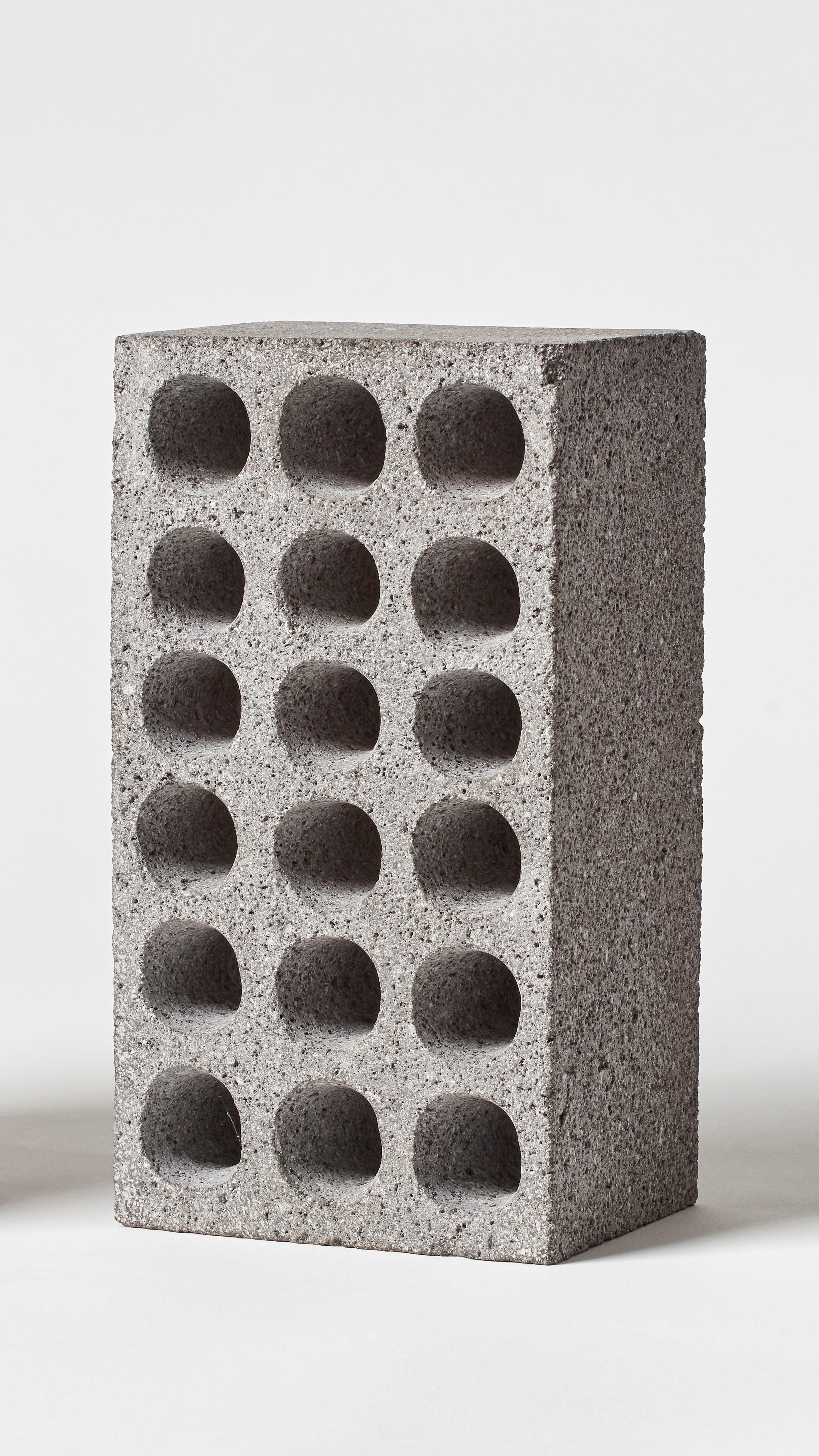 BRICK von Estudio Rafael Freyre
Abmessungen: B 12,5 T 9 x H 23 cm 
MATERIALIEN: Anden-Steine
Auch verfügbar: Andere Oberflächen verfügbar.

Der Ziegelstein ist ein allgemeines konstruktives Element, das Teil des städtischen Imaginären ist. In
