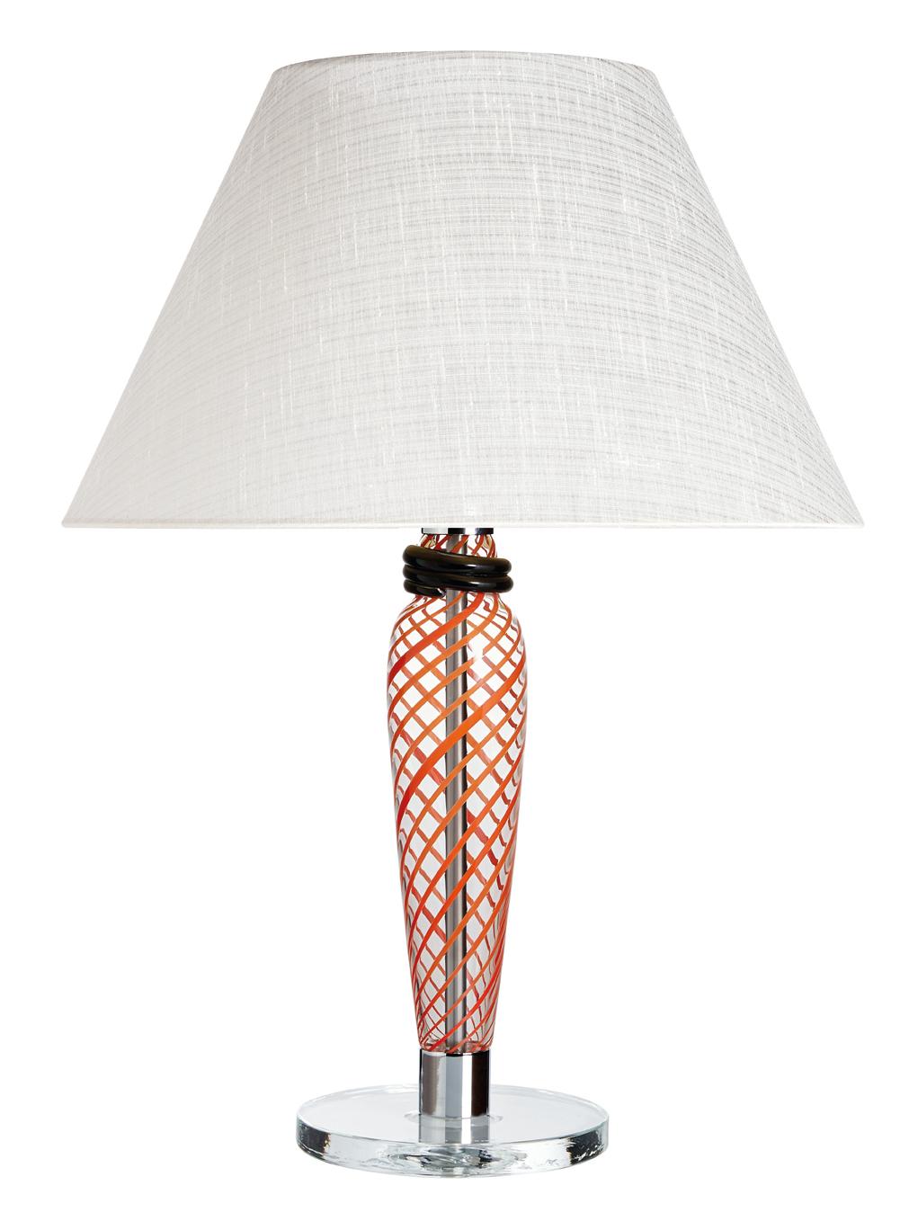 Table lamp with Murano glass column, black/red transparent glass base, truncated cone-shaped fabric shade, and metal fixtures in polished chrome. The lamp was designed by Carlo Moretti in 1995.



Carlo Moretti: An artisan factory

Strolling