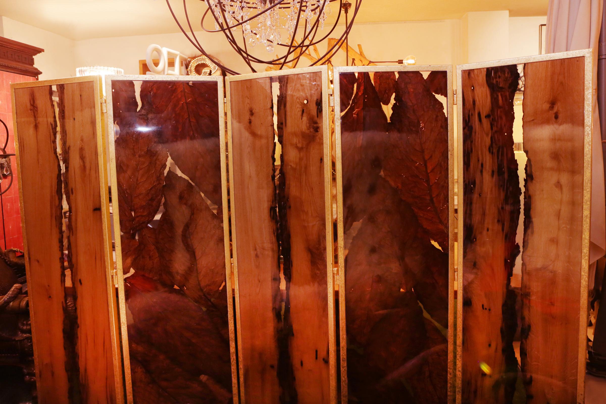 Folding screen bricole and tobacco leaves with resin,
all handcrafted with 5 metal gilded panels frame. With
3 panels in Venetian solid bricole wood taken in high
quality translucent resin and with 2 panels in Virginia
tobacco leaves taken in