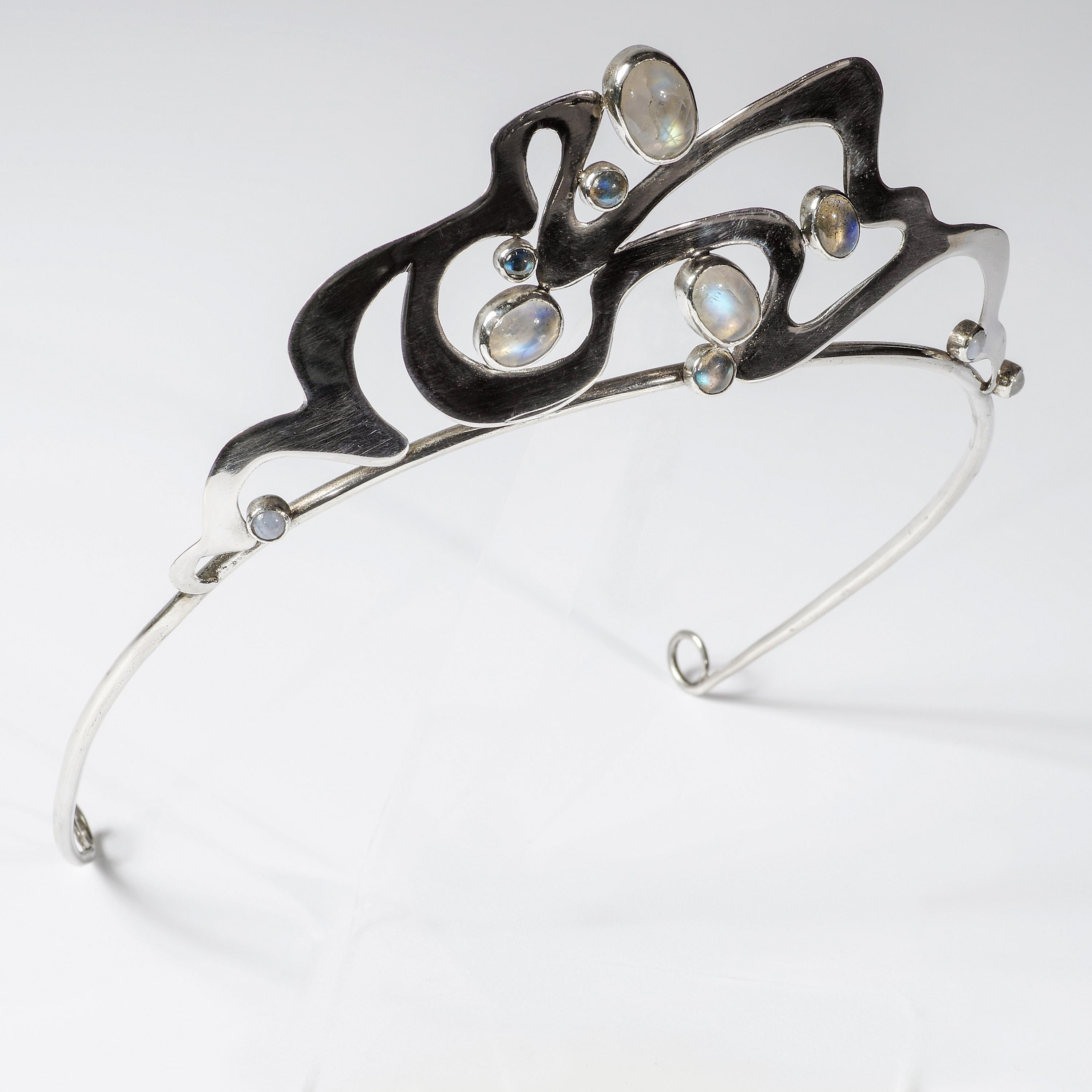 Stunning in every way and exceptionally rare, this beautifully hand-crafted tiara from the Art Nouveau-era (circa 1910) is composed of a simple, elegantly tapered wire band for positioning the piece atop the head and a swirling geometric silver