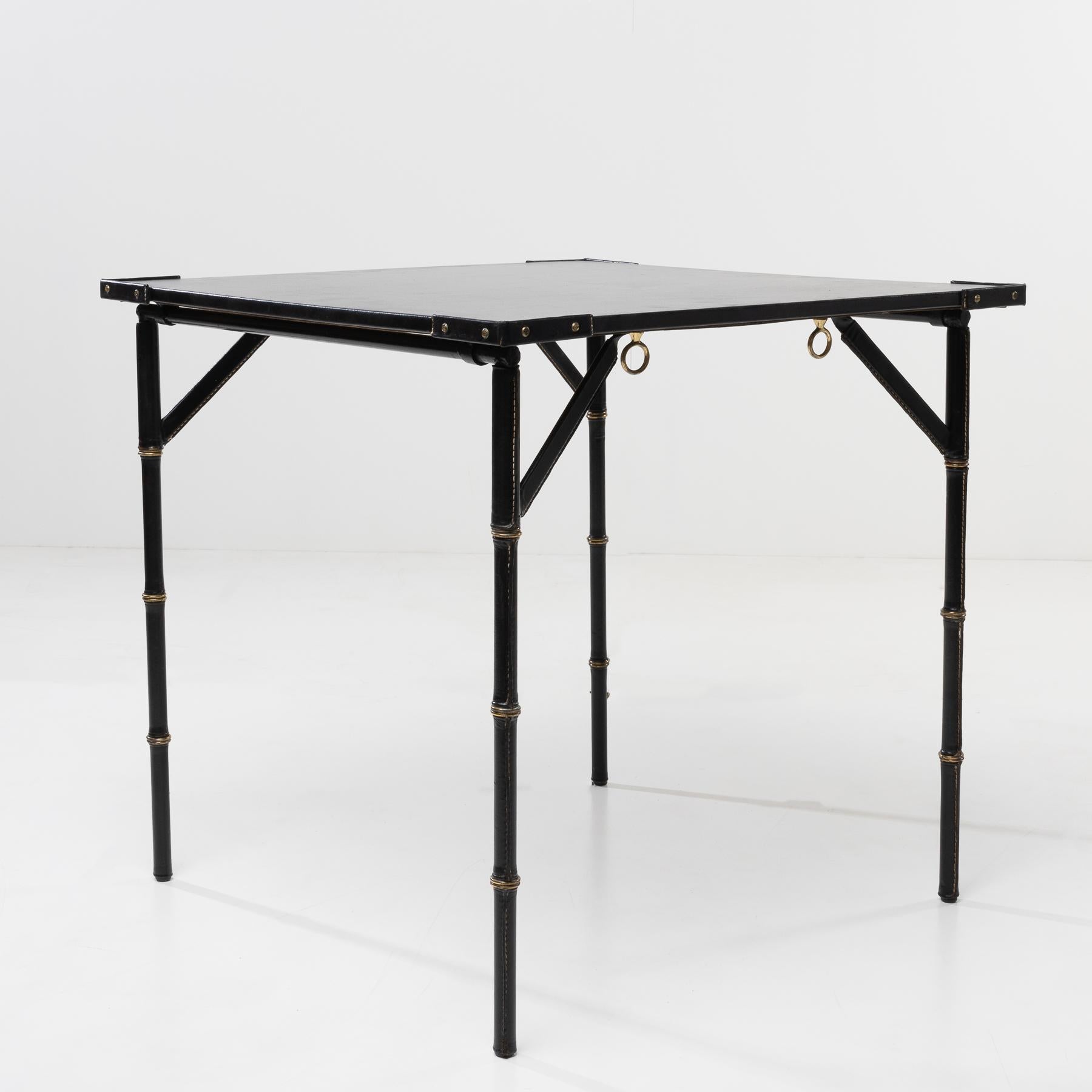 Bridge table with folding legs, entirely covered in saddle stitched leather.
Steel legs covered in saddle stitched black leather.
The top also covered in leather, the accessories in bronze.
This bridge table or game table can also be used as a