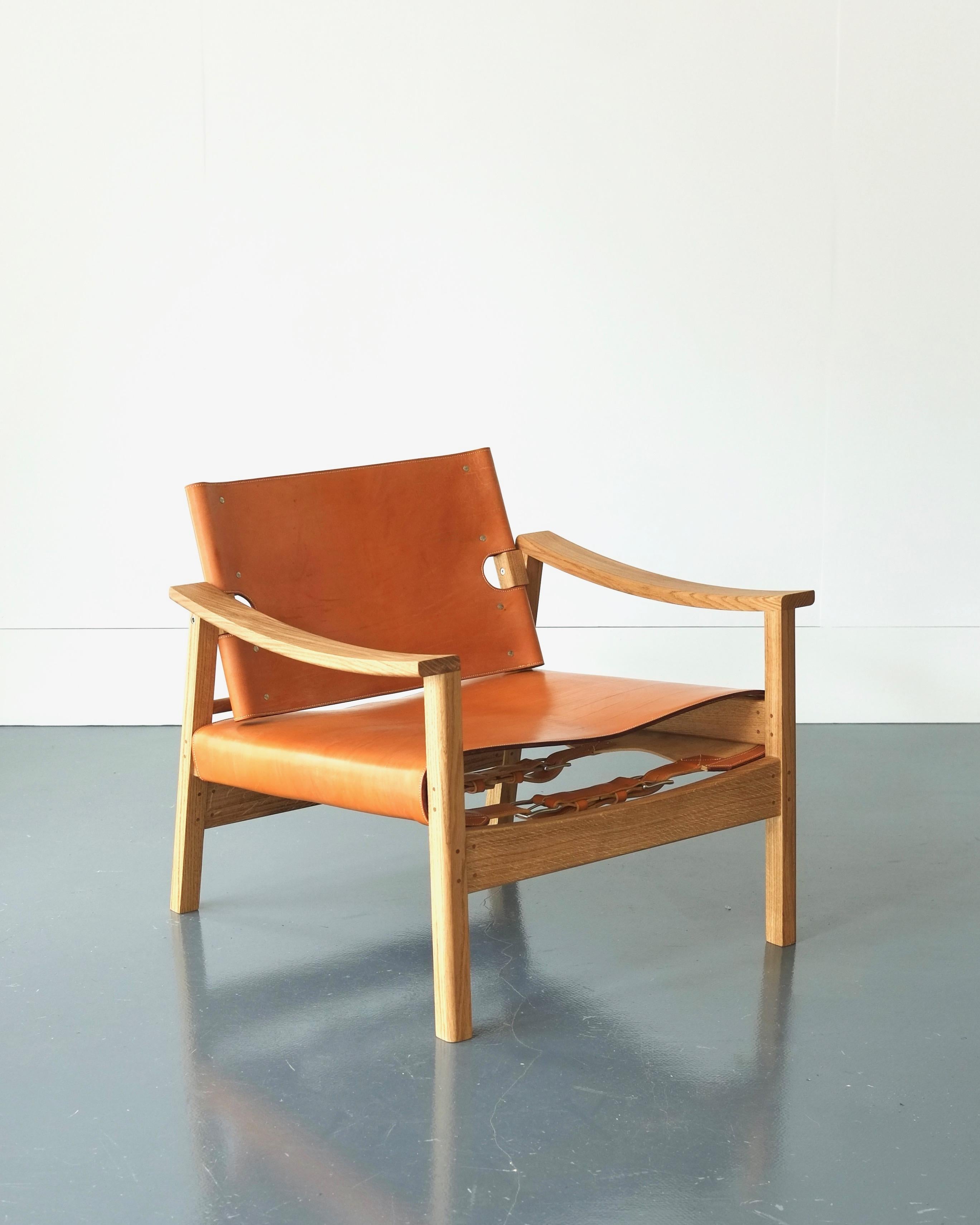 A melding of Brazilian and Scandinavian midcentury design, this lounge chair takes the classic Danish combination of oak and leather and applies it to a shapely hand joined and turned frame. Oak bark tanned bridle leather is hand cut, burnished and