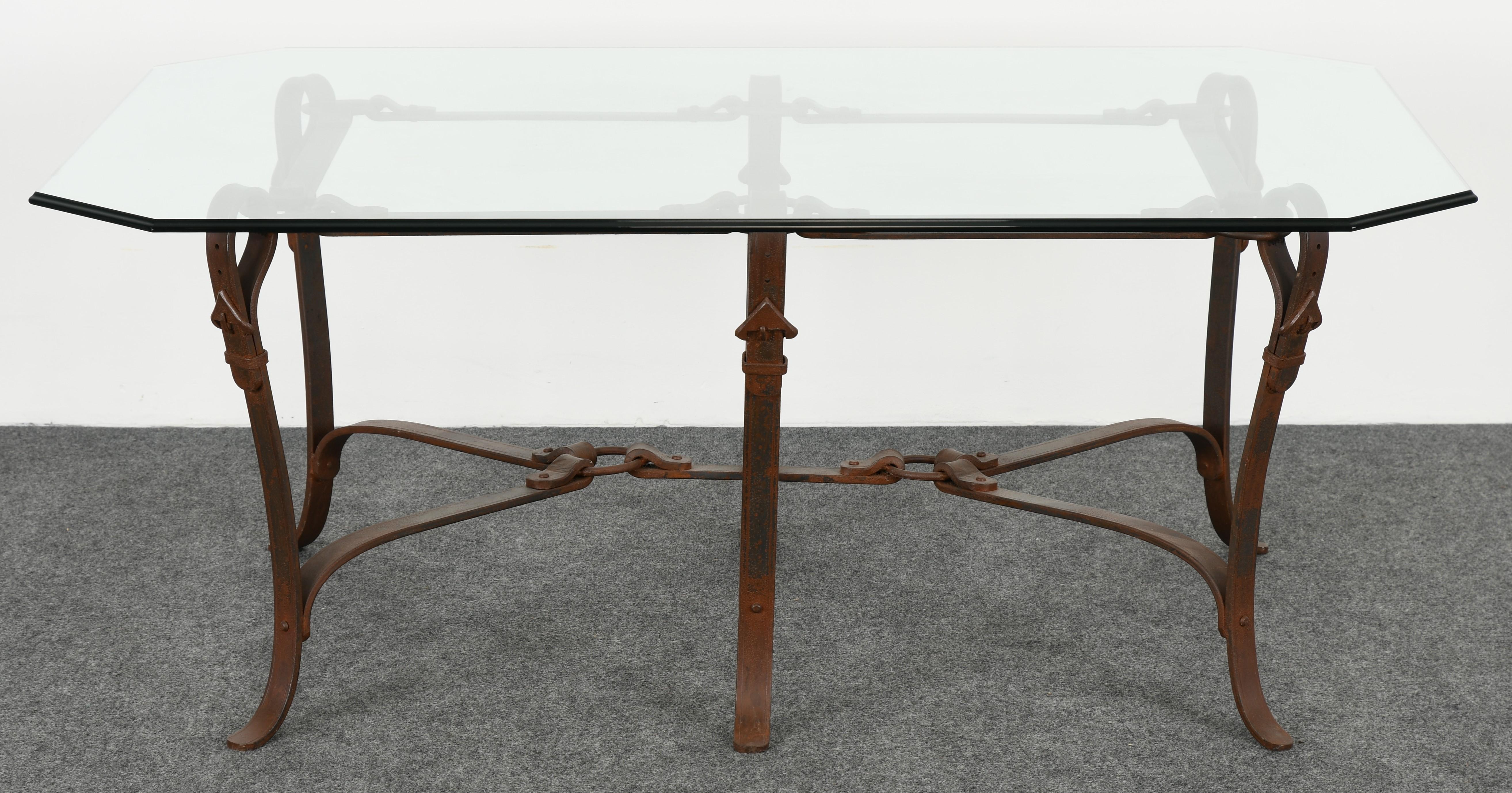 Bridle strap coffee table in the manner of Hermes made of wrought iron with original rust patinated finish. Glass has some minor scratches, however, not distracting.

Dimensions: 23.75