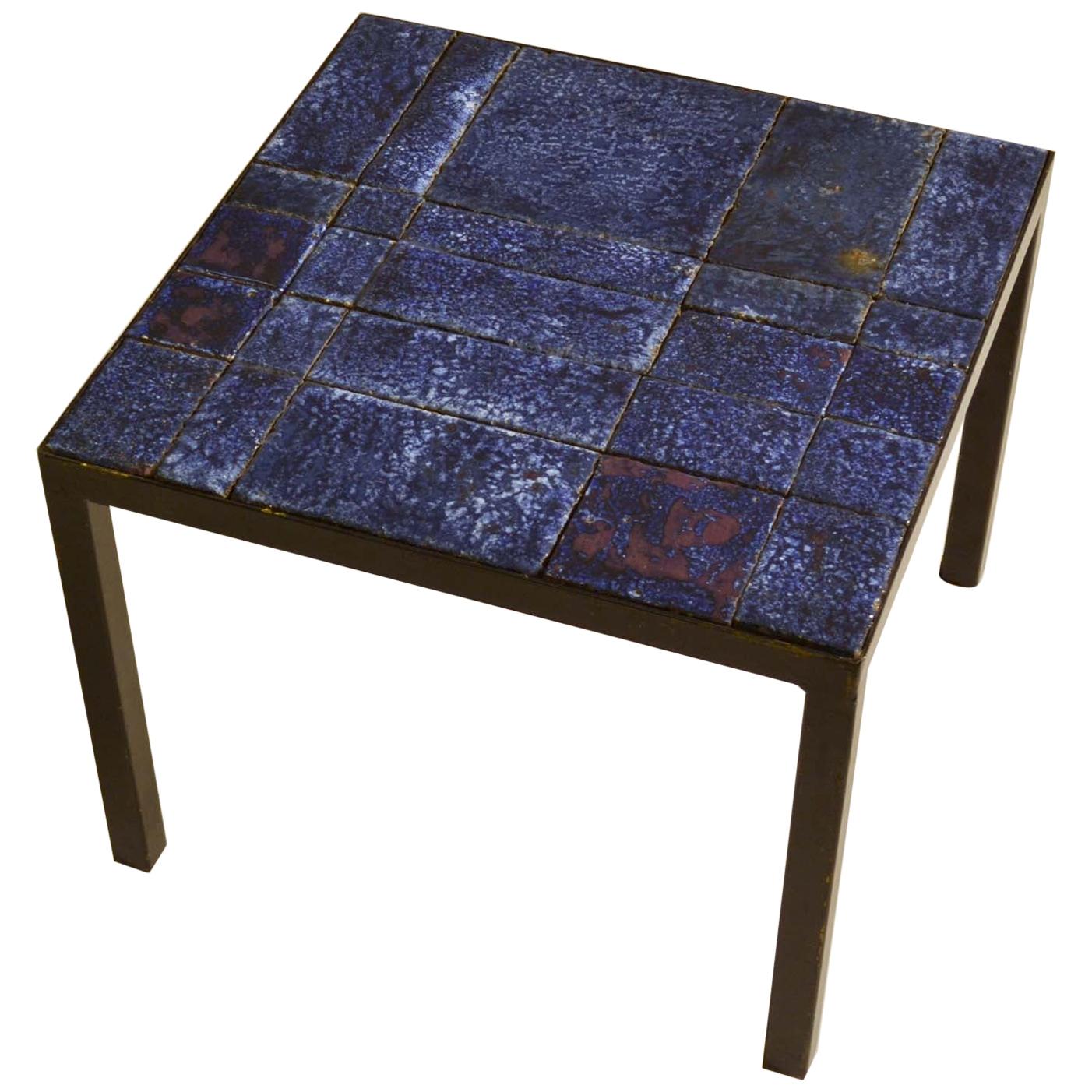 Tiled side table in stoneware was born out experiments in clay in the mid-20 century in Italy. The bold bright deep blue glazes and geometric patterns emphasize on the irregular brick work formation of the tiles and its gleaming uneven surfaces. The