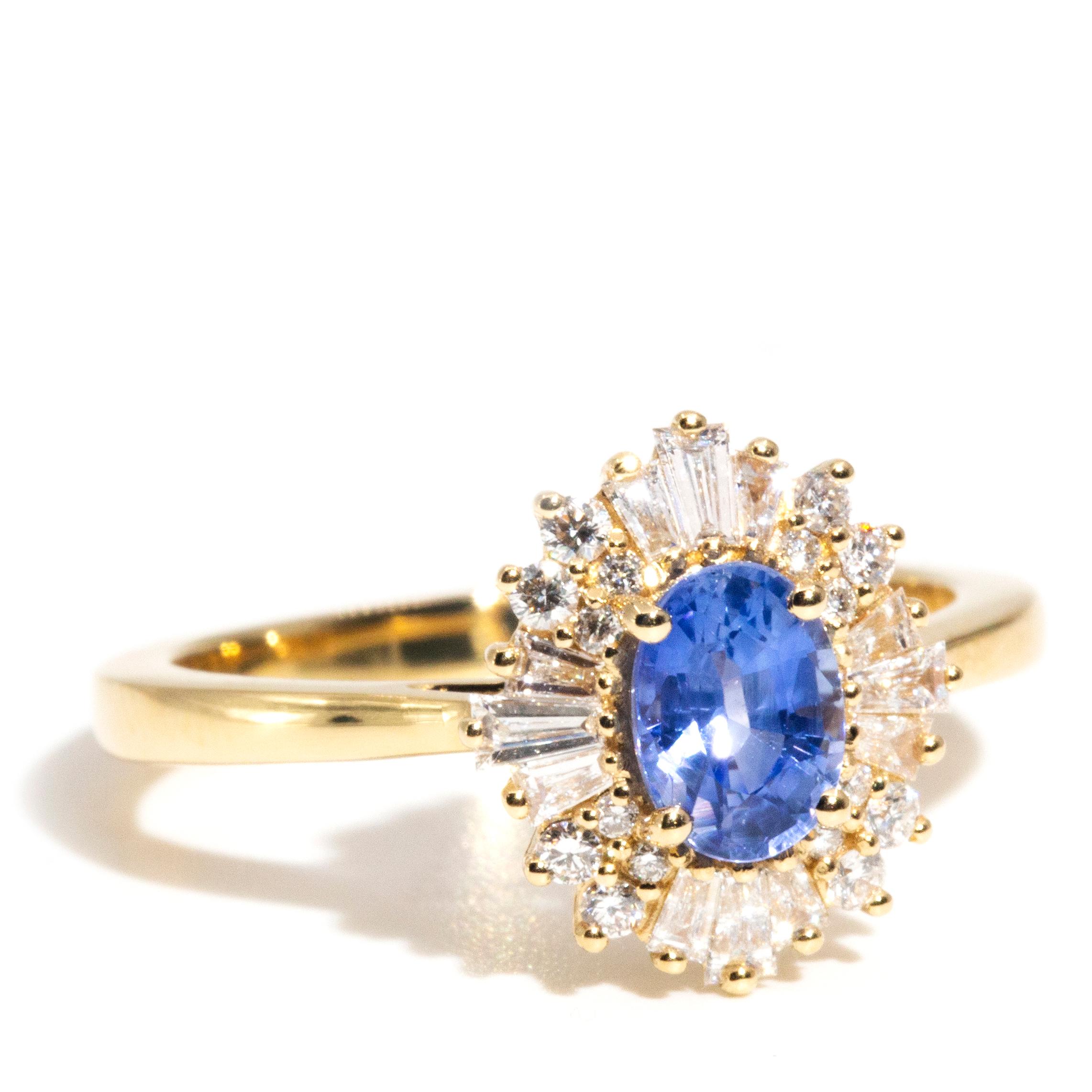 Crafted with adoration in shimmering 18 carat yellow gold, this wonderful contemporary ballerina halo cluster ring features a captivating 0.49 carat oval bright blue Ceylon sapphire encompassed by 0.48 carats of glistening round brilliant and