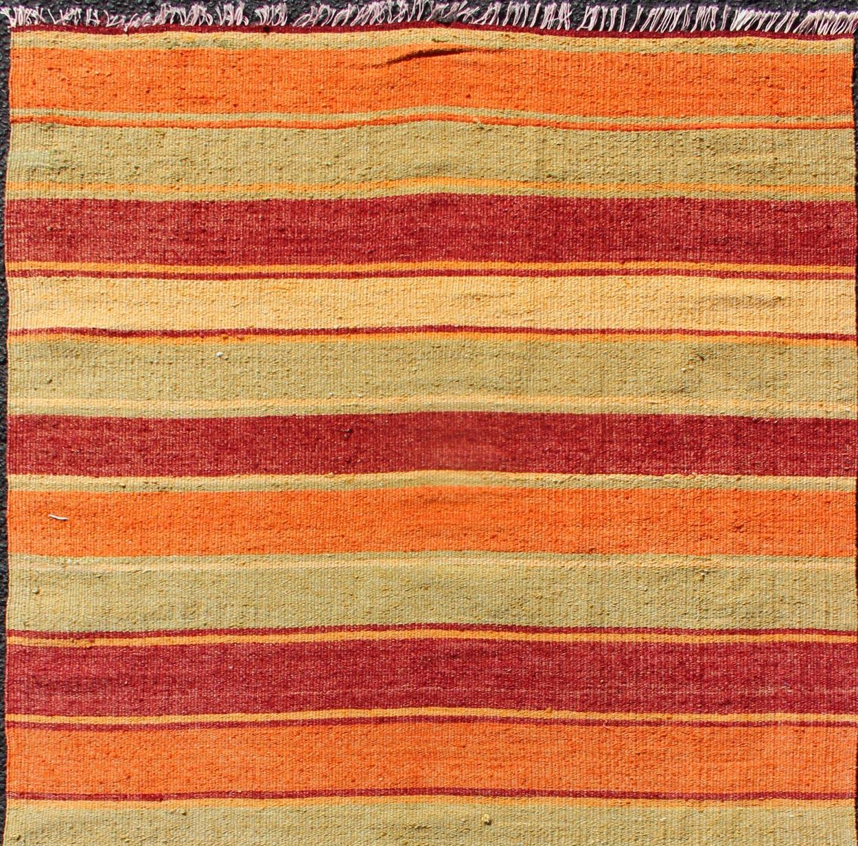 Turkish Kilim runner with stripes in red, green, yellow, orange, rug TU-NED-607, country of origin / type: Turkey / Kilim, circa mid-20th century

Woven during the mid-20th century in Turkey, this designer Kilim is decorated with a horizontal