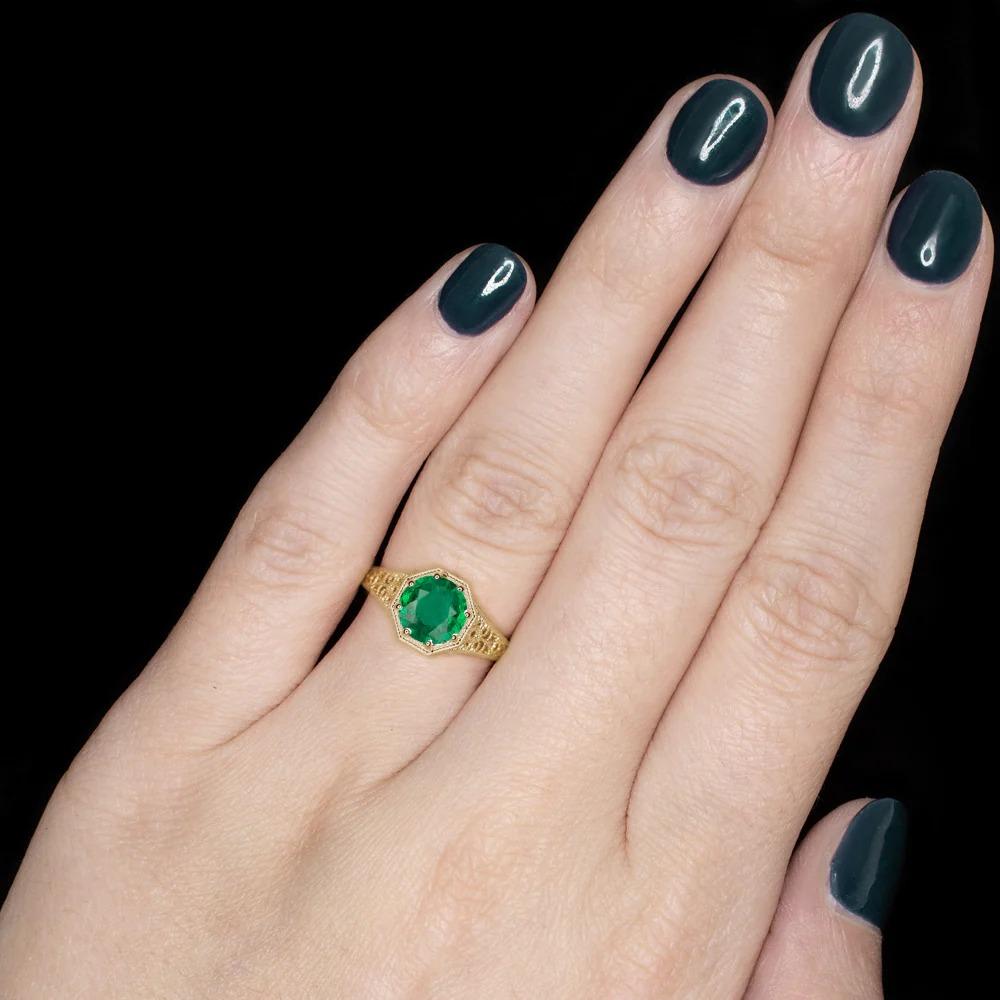 gorgeous and classic emerald ring combines rich color with a romantic, vintage style design. This 1.26ct emerald displays vibrant, bright green color and a large spread! The solitaire setting is embellished with filigree curls and engraving for a