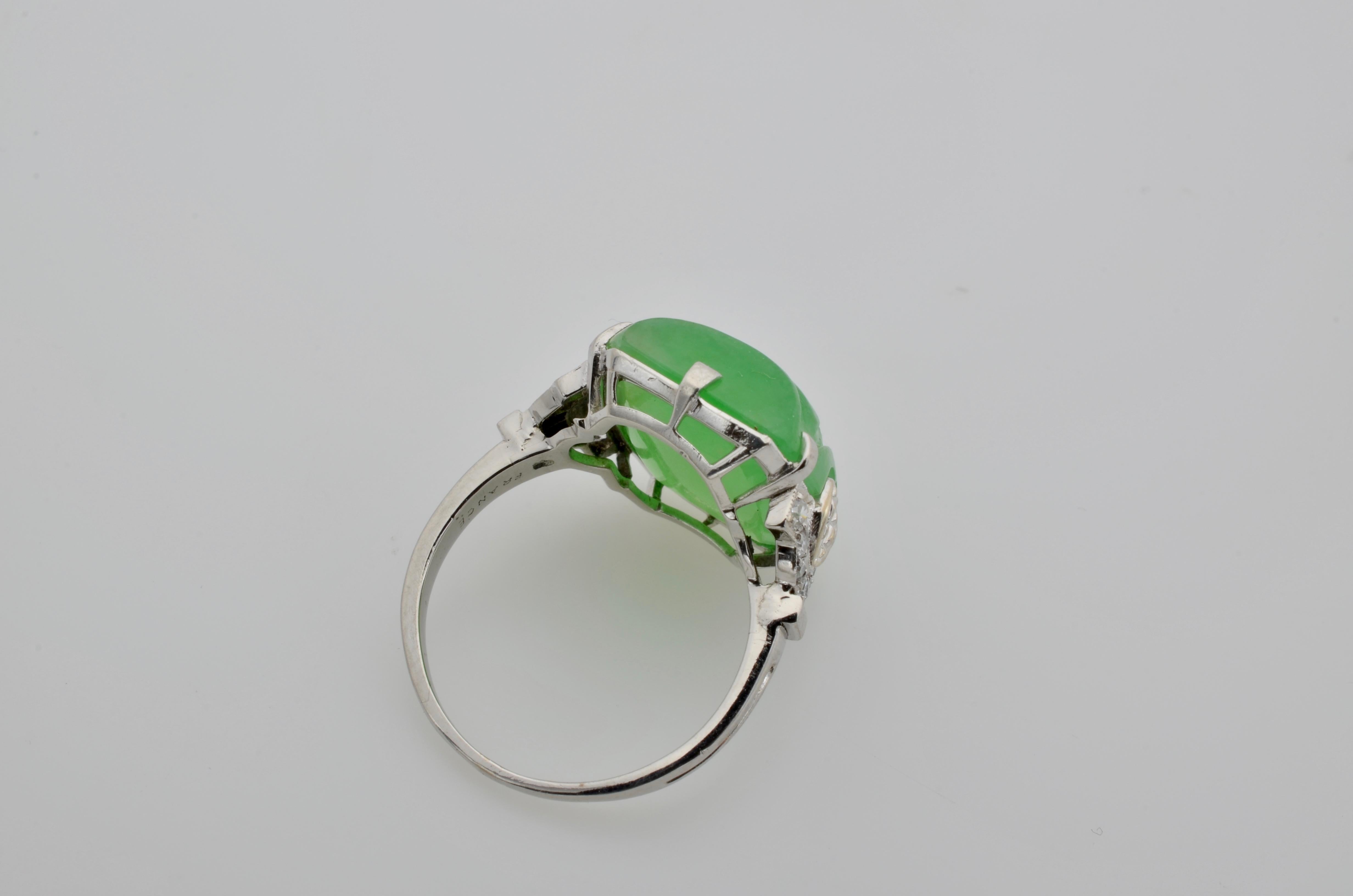 Engraved spirals sit perfectly in the center of this bright spring green Jadeite Jade ring. Made in France and set in Platinum this ring has 0.15 carats total weight of old mine cut diamonds embellished on the sides for exquisite detail. This is a