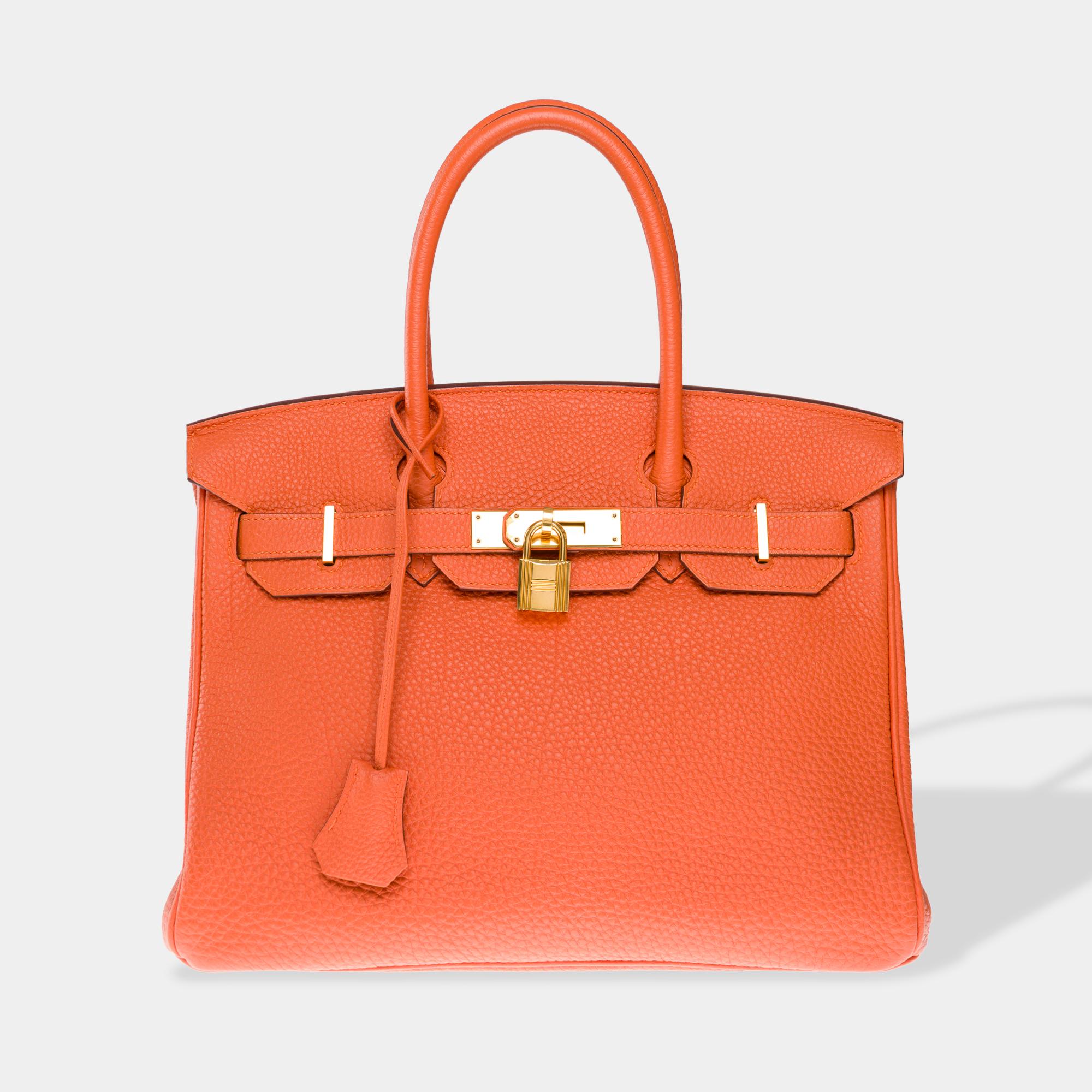 Magnificent​ ​and​ ​luminous​ ​Hermès​ ​Birkin​ ​30​ ​handbag​ ​in​ ​orange​ ​Togo​ ​calfskin,​ ​gold-tone​ ​metal​ ​trim,​ ​and​ ​double​ ​orange​ ​leather​ ​handles​ ​for​ ​hand​ ​carrying

Flap​ ​closure
Orange​ ​leather​ ​lining,​ ​one​