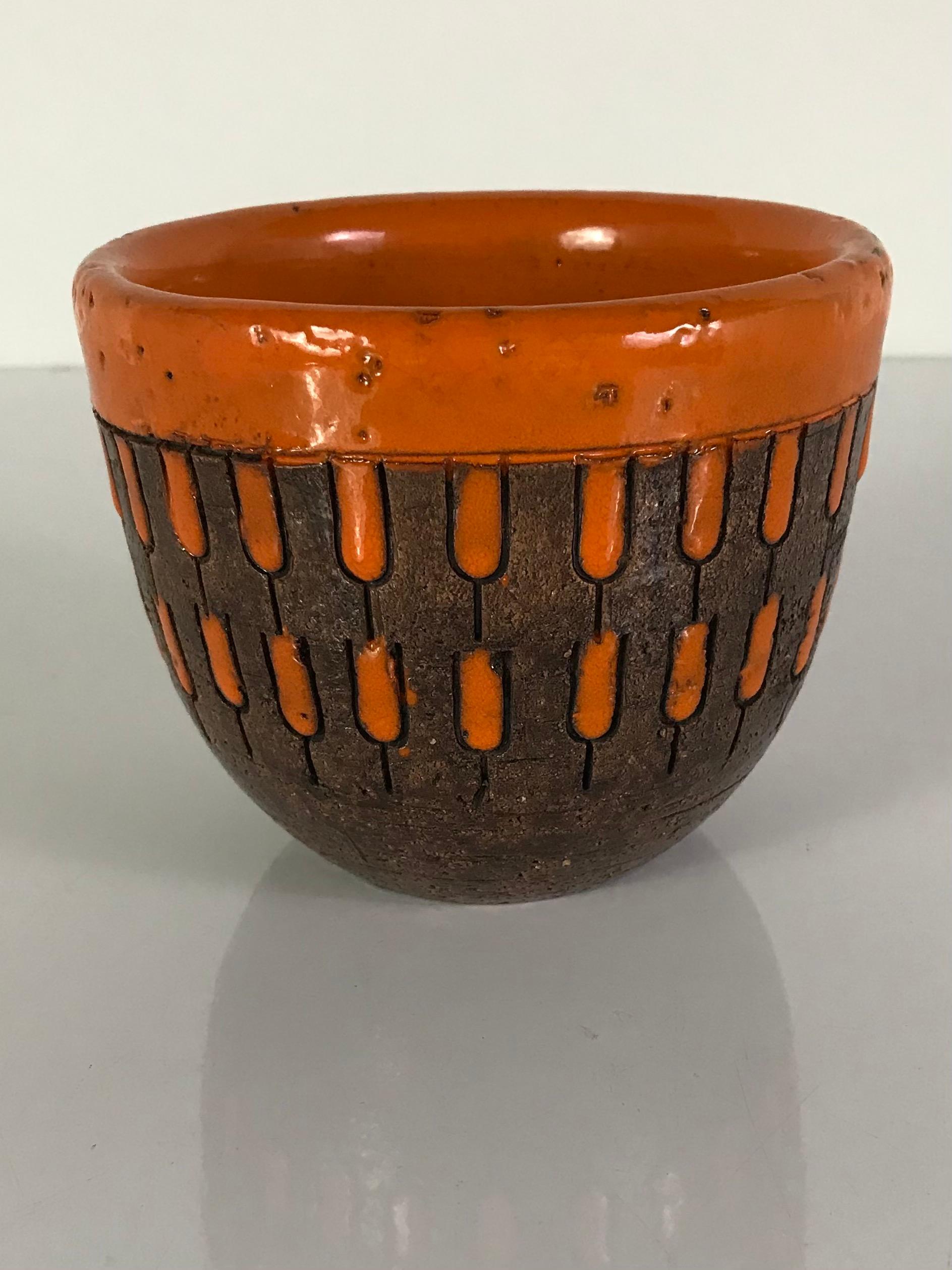 Bright and fun small mid century pottery bowl by Aldo Londi for Bitossi Italy 1960s. Having a glazed rustic finish and high gloss glaze of bright orange on the rim and on the incised design.
In excellent condition with no damage or issues. Stamped
