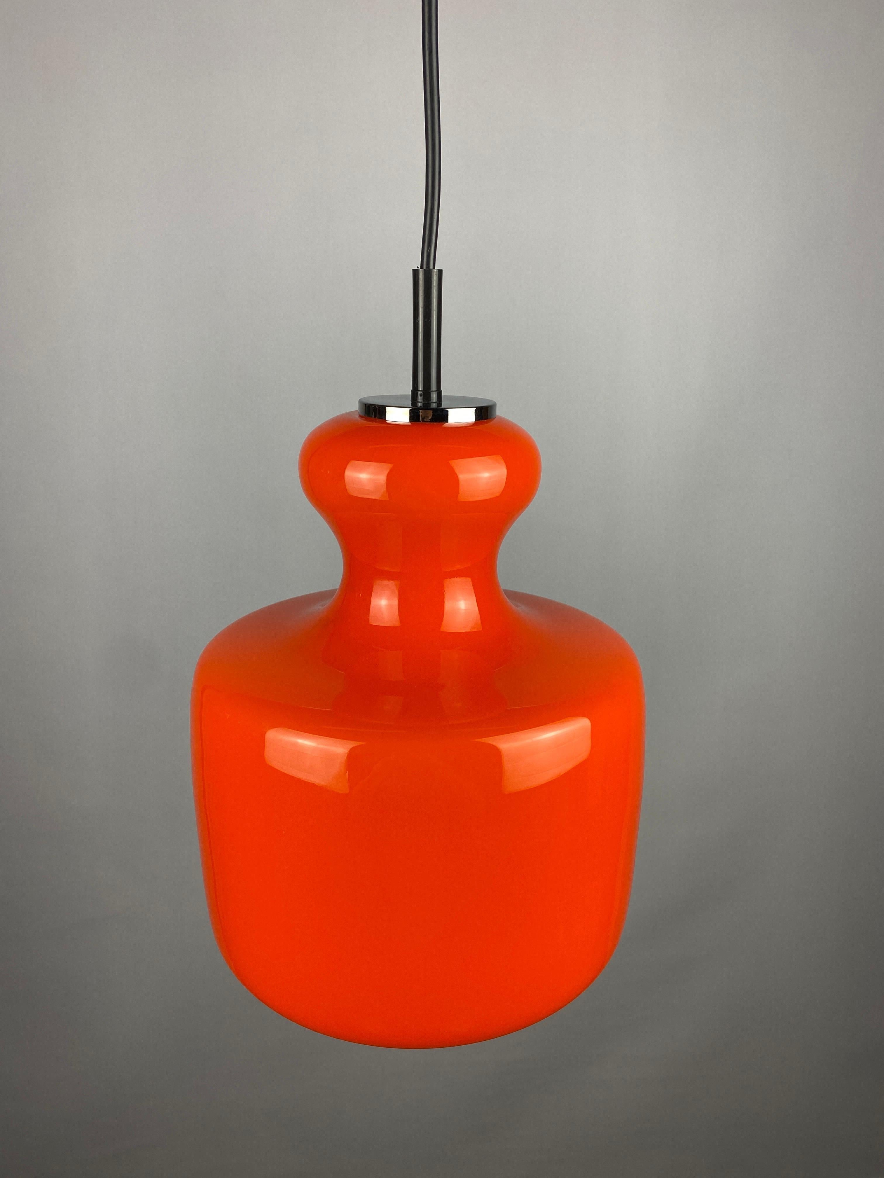 Beautiful German design by Peill and Putzler, produced around 1960. Has a nice bright orange color and gives a very warm light. 

Typical design of the German makers, also resembles the Swedish designs. More colored glass pendant lights in