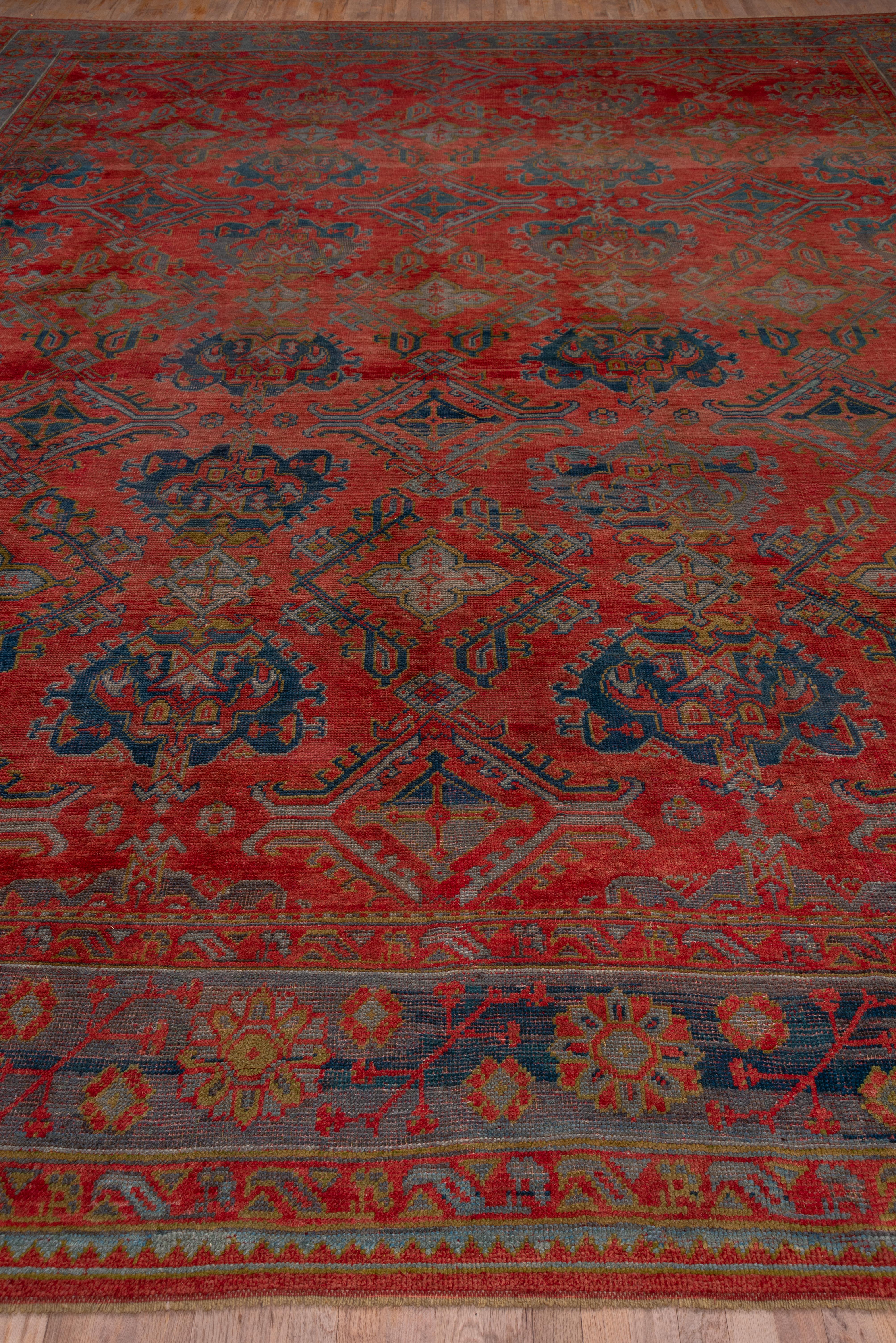 The abrashed soft madder red field of this western Turkish workshop carpet displays an all-over yaprak (