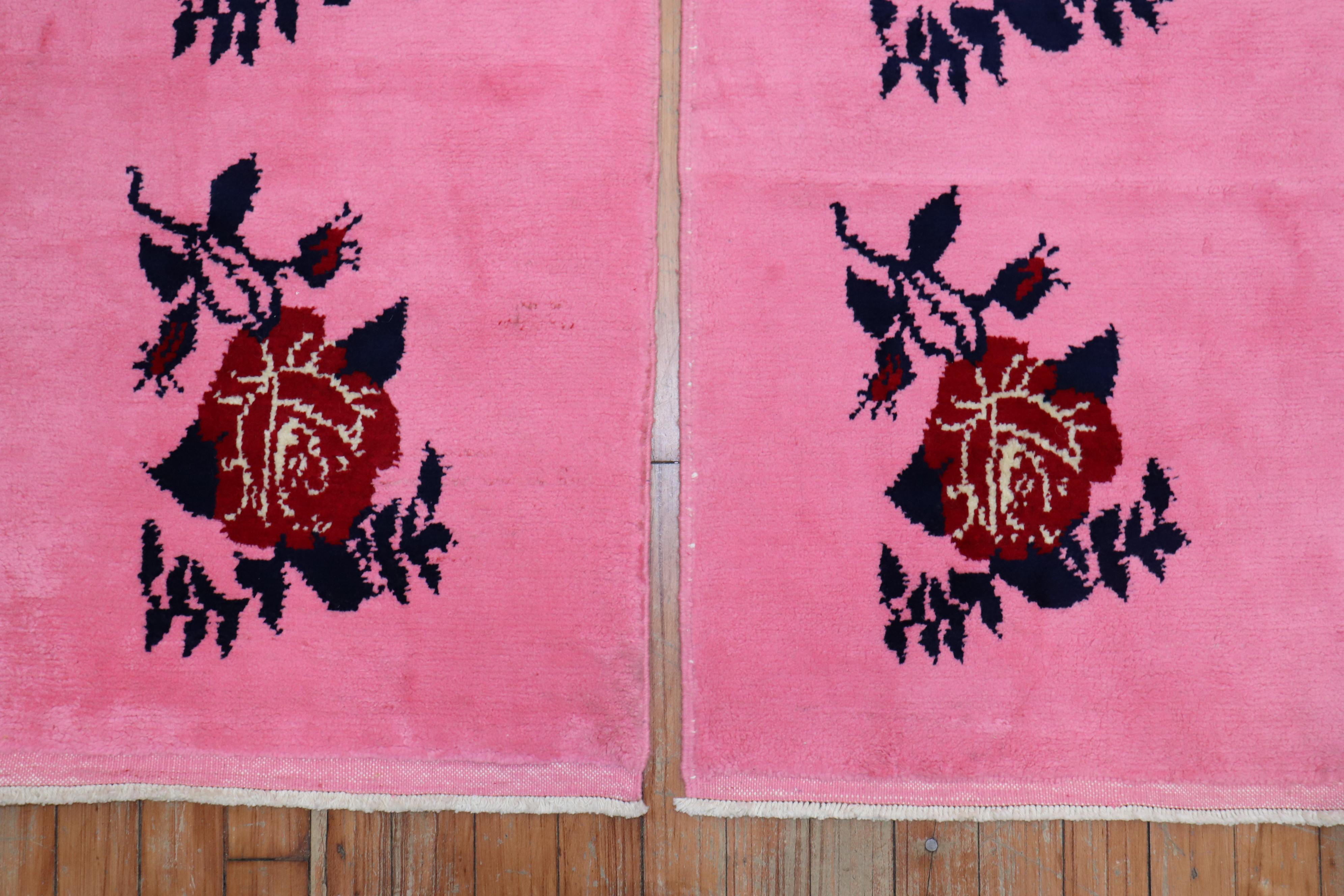 A pair of mid-20th century Turkish Anatolian rugs with borderless flower motifs on a bubble gum bright pink ground. 

Measuring: 1'7