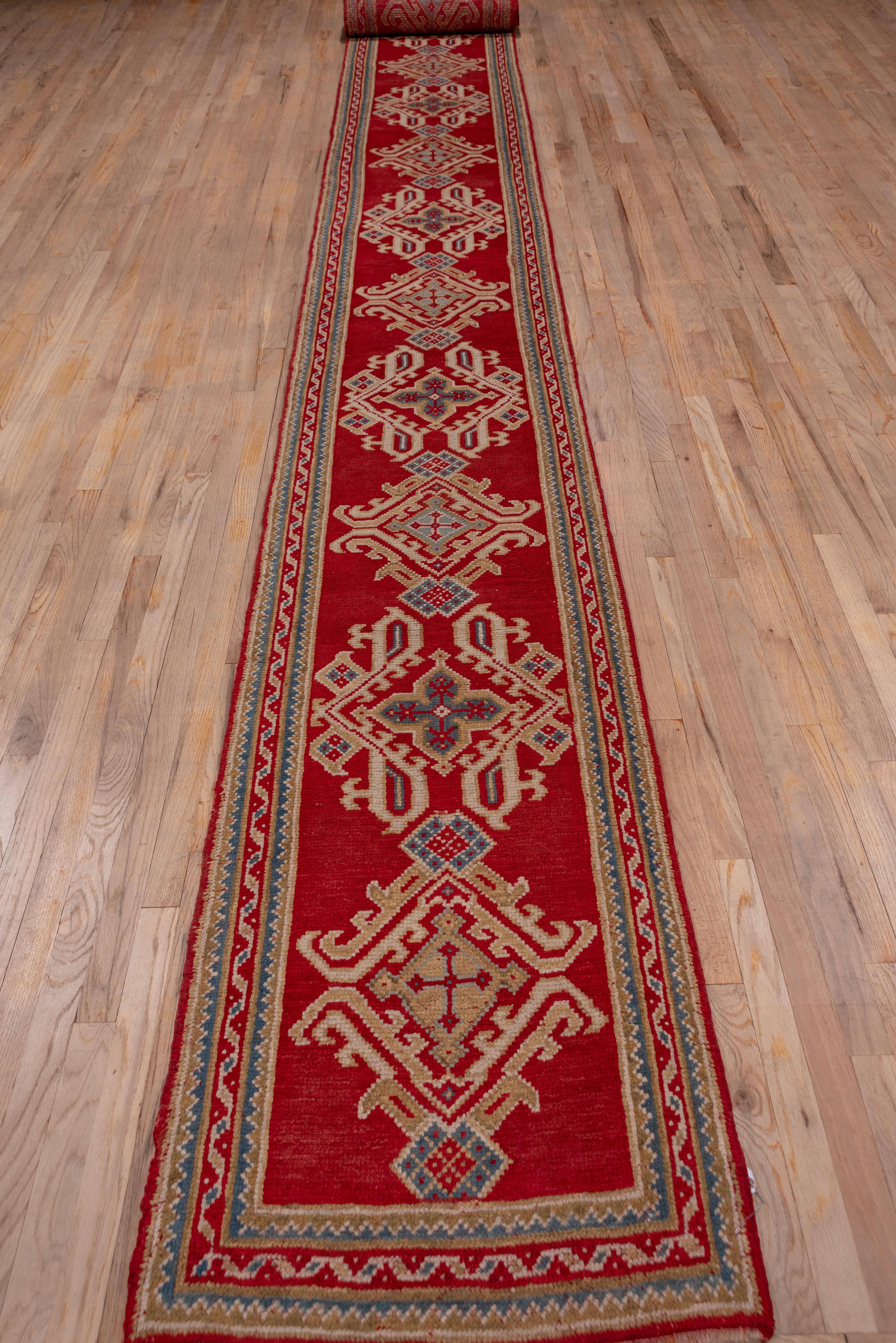 A single column Yaprak (Leaf) design fills the narrow Turkey Red field side to side and is accented in lime, ivory, light blue and rust. The pattern is compressed laterally, but remains uncluttered.