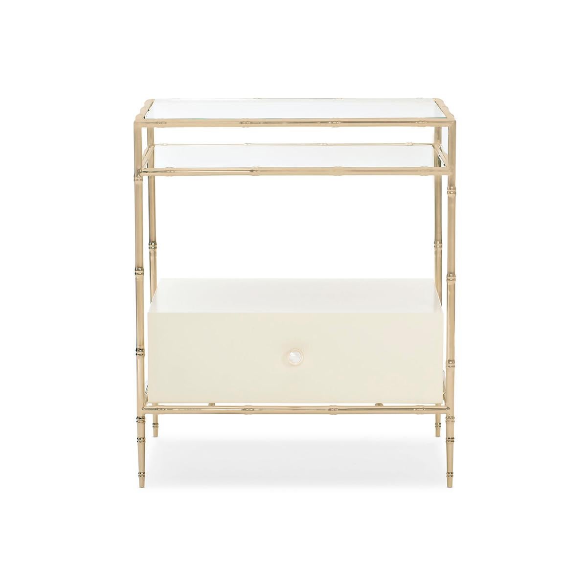 Classic style with a modern perspective, this bedside table feels fresh and light in any environment. The traditional lines of its metal frame are updated with a bamboo motif highlighted with a Whisper of Gold finish. Clear tempered glass gives its