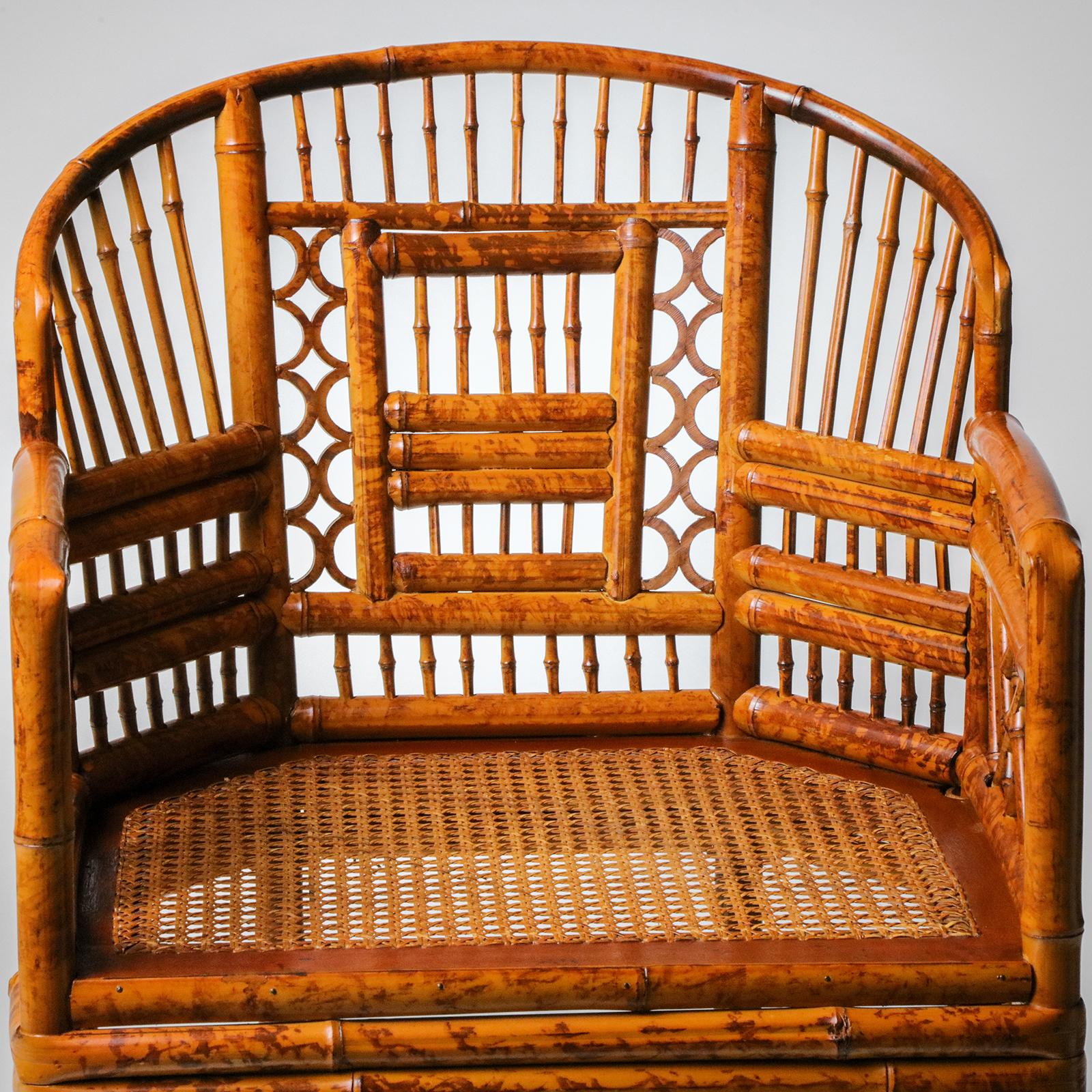 Sillón inglés vintage estilo Regencia Brighton Pavilion, fabricado en bambú y ratán. Presenta un marco de bambú en forma de herradura con calados de diseños geométricos tradicionales. El bambú con acabado estilo tortuga. Excelente estado, procedente