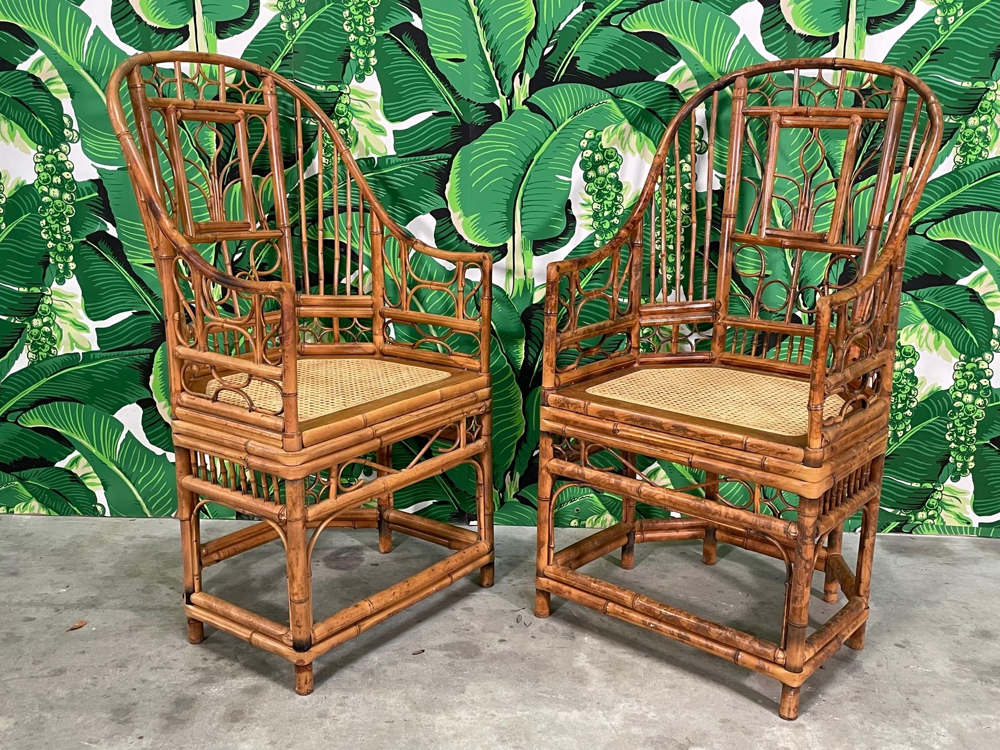 Pair of tortoise bamboo Brighton Pavilion style arm chairs feature cane seats and intricate fretwork in geometric and foliate motifs. Would work well in safari, chinoiserie, boho, and just about any decor style. Good condition with minor
