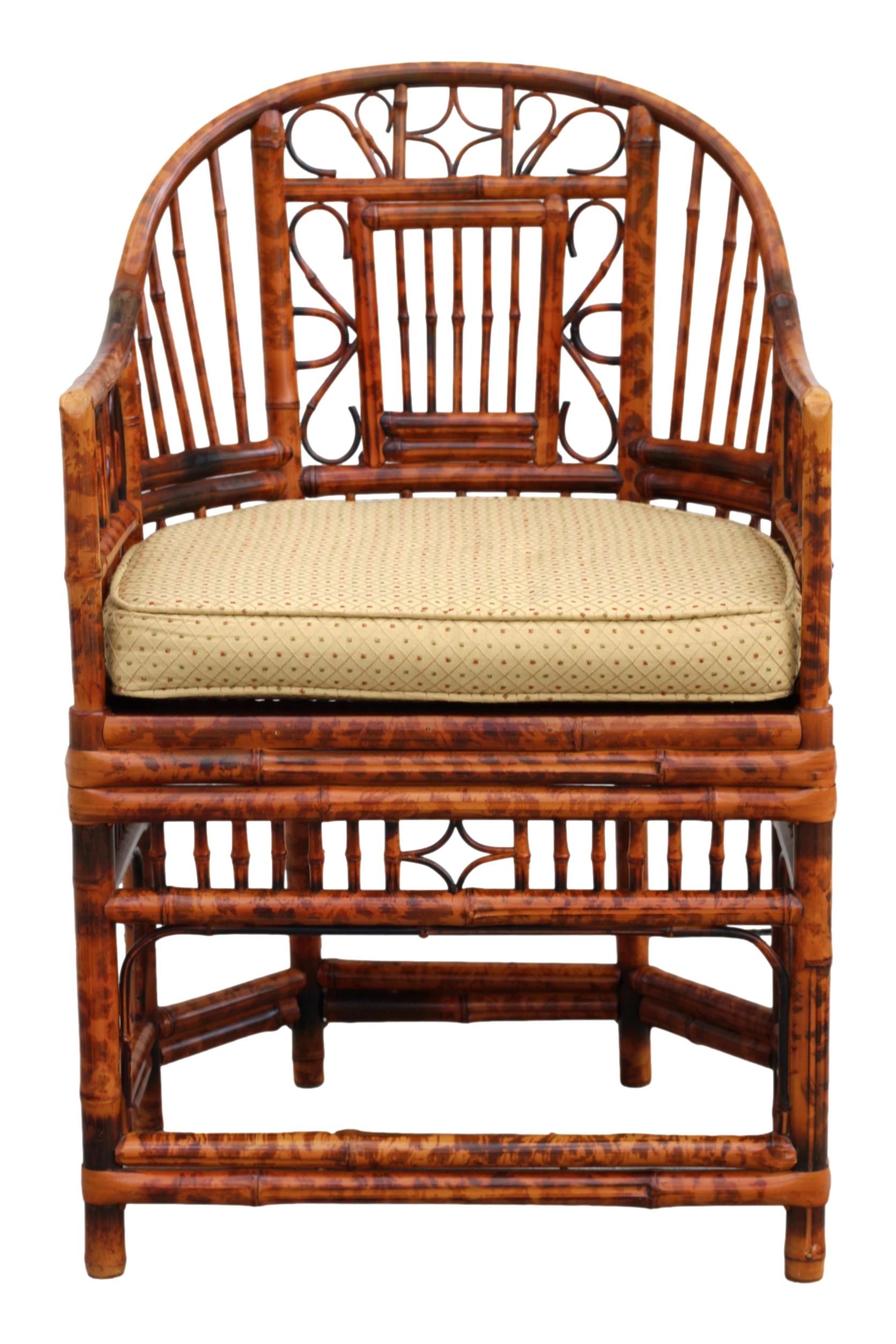 Stunning pair of burnt bamboo armchairs with gracefully shaped horseshoe frames, in the Brighton Pavilion style. These Chinese Chippendale chairs feature a beautiful tortoiseshell finish, caned-bottom seats, and intricate bamboo open fretwork. Loose