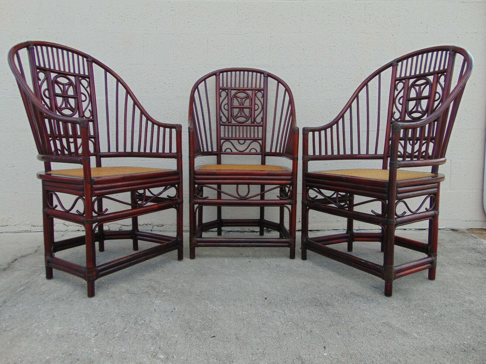 Vintage Brighton Pavilion style rattan armchairs with original finish and cane seating. A graceful rattan frame is decorated with open fretwork featuring a scroll pattern. Indian River Plantation plaque.

Chairs retain their vintage character with