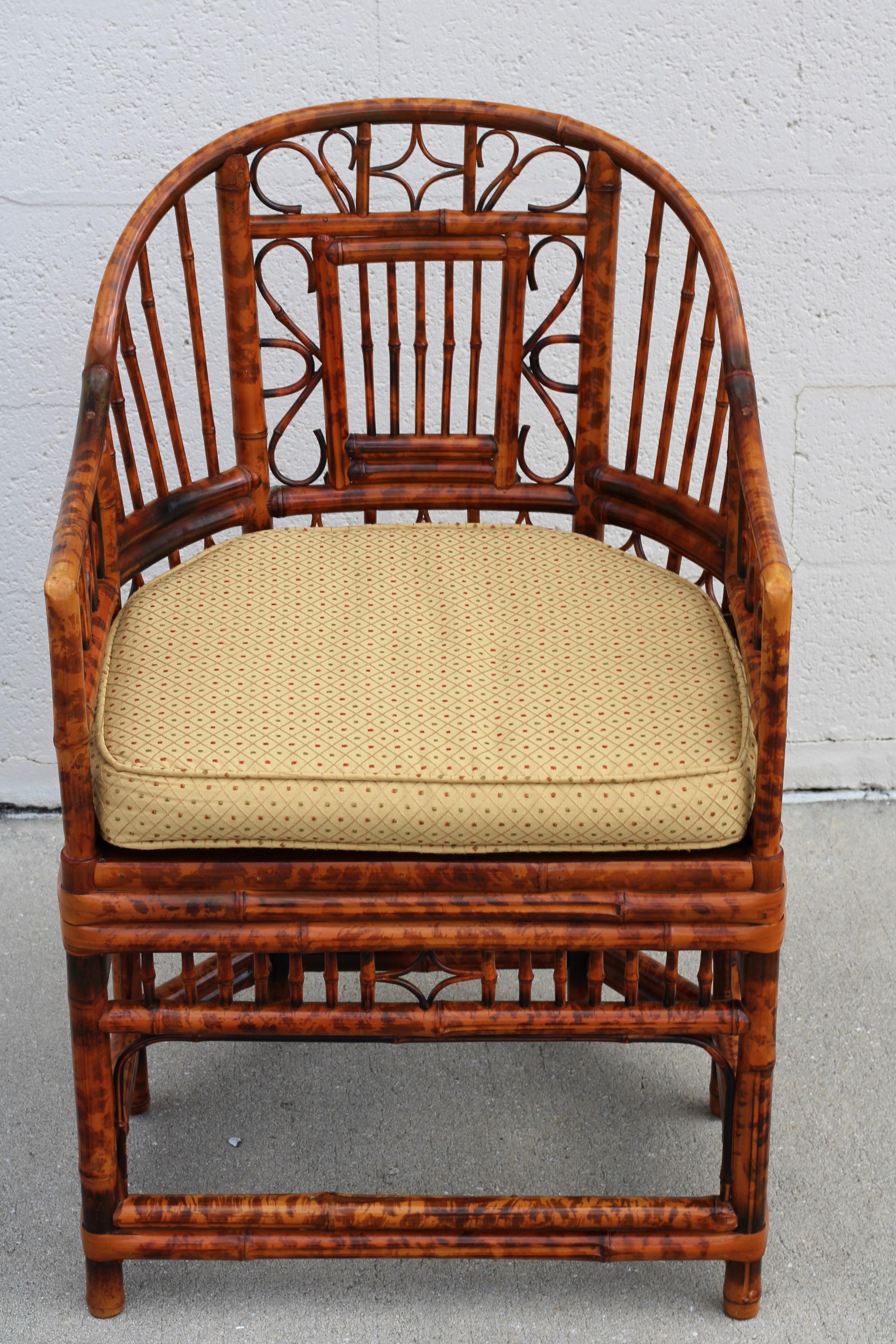 Stunning pair of burnt bamboo armchairs with gracefully shaped horseshoe frames, in the Brighton Pavilion style. These Chinese Chippendale chairs feature a beautiful burnt bamboo tortoiseshell finish, caned-bottom seats, and intricate bamboo open