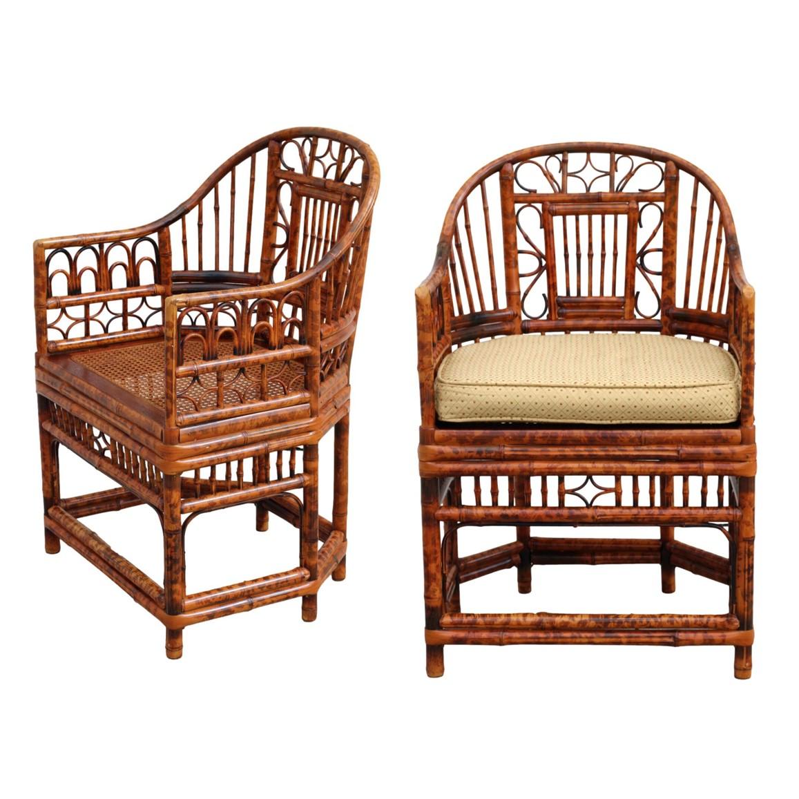 Stunning pair of burnt bamboo armchairs with gracefully shaped horseshoe frames, in the Brighton Pavilion style. These Chinese Chippendale chairs feature a beautiful tortoiseshell finish, caned-bottom seats, and intricate bamboo open fretwork. Loose