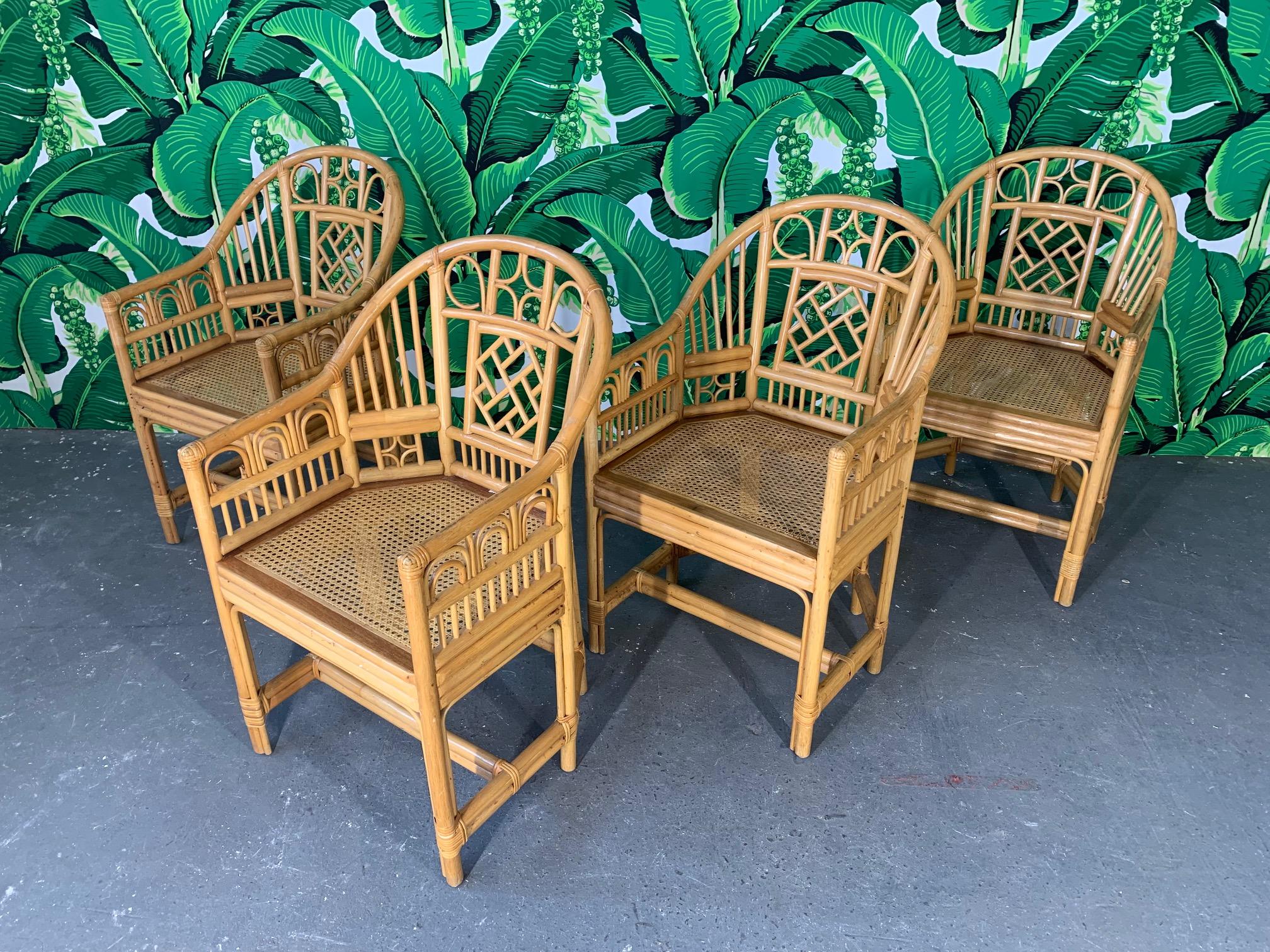 Set of 4 Brighton Pavilion style rattan dining armchairs feature bamboo construction, cane seats, and chinoiserie style detailing. Very good condition.
