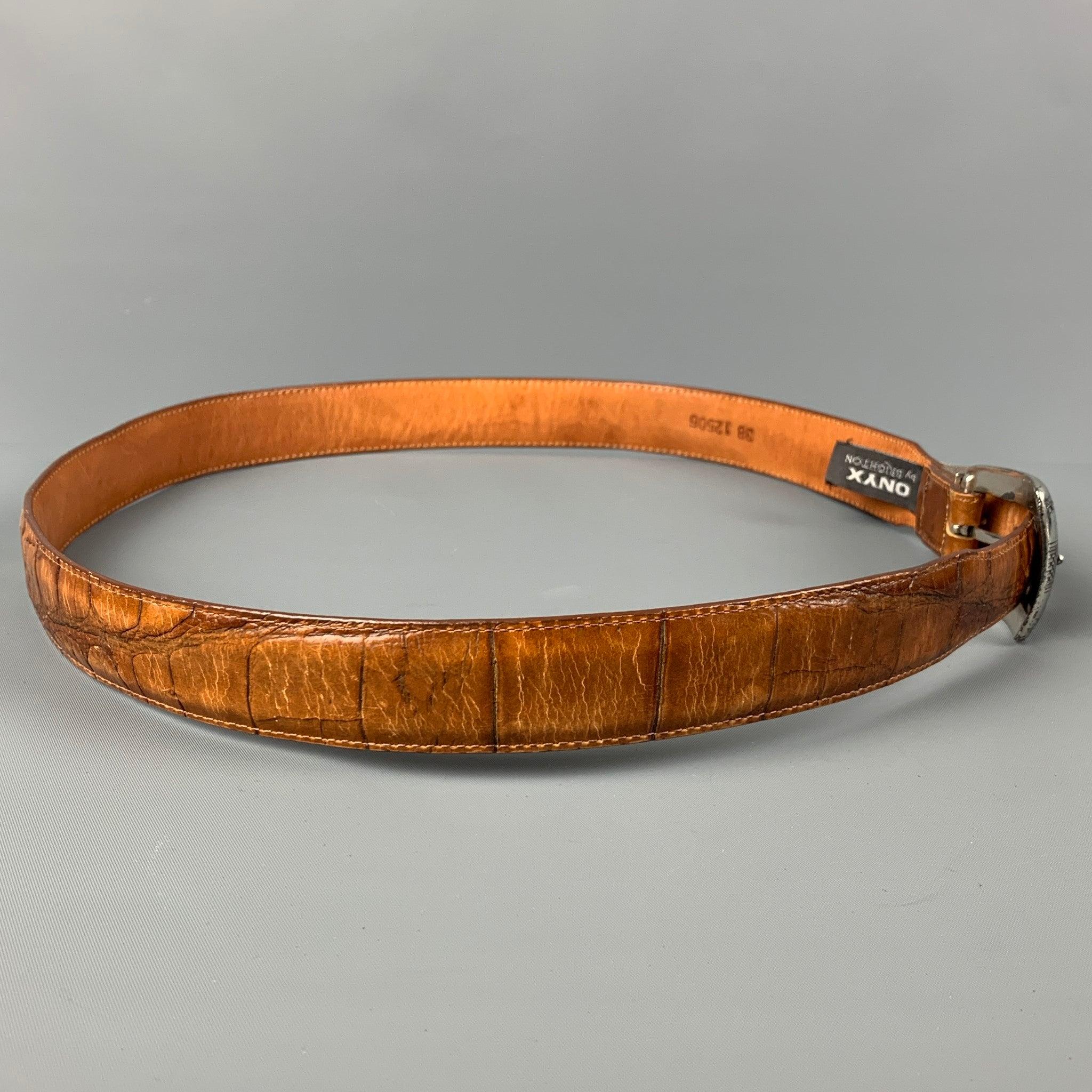 BRIGHTON belt comes in a tan embossed leather featuring a silver tone buckle closure.
 Good
 Pre-Owned Condition. 
 

 Marked:  38 12506Length: 42.5 inches Width: 1.25 inches Fits: 38 inches - 41 inches Buckle: 2.25 inches 
  
  
  
 Sui Generis