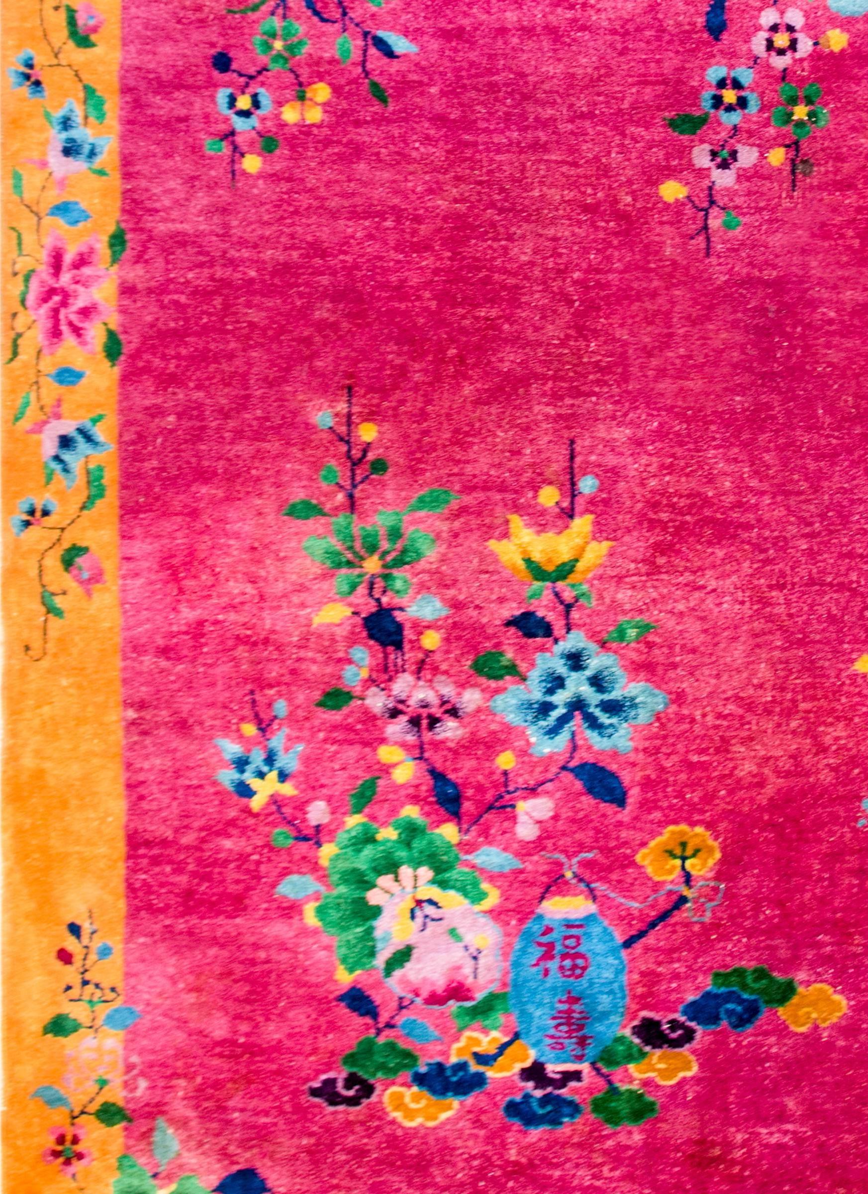 A brilliant early 20th century Chinese Art Deco rug with an asymmetrical floral pattern containing multicolored potted peonies in opposite corners, on a bold pink background. The border is wide, with a complimentary multicolored peony pattern on a