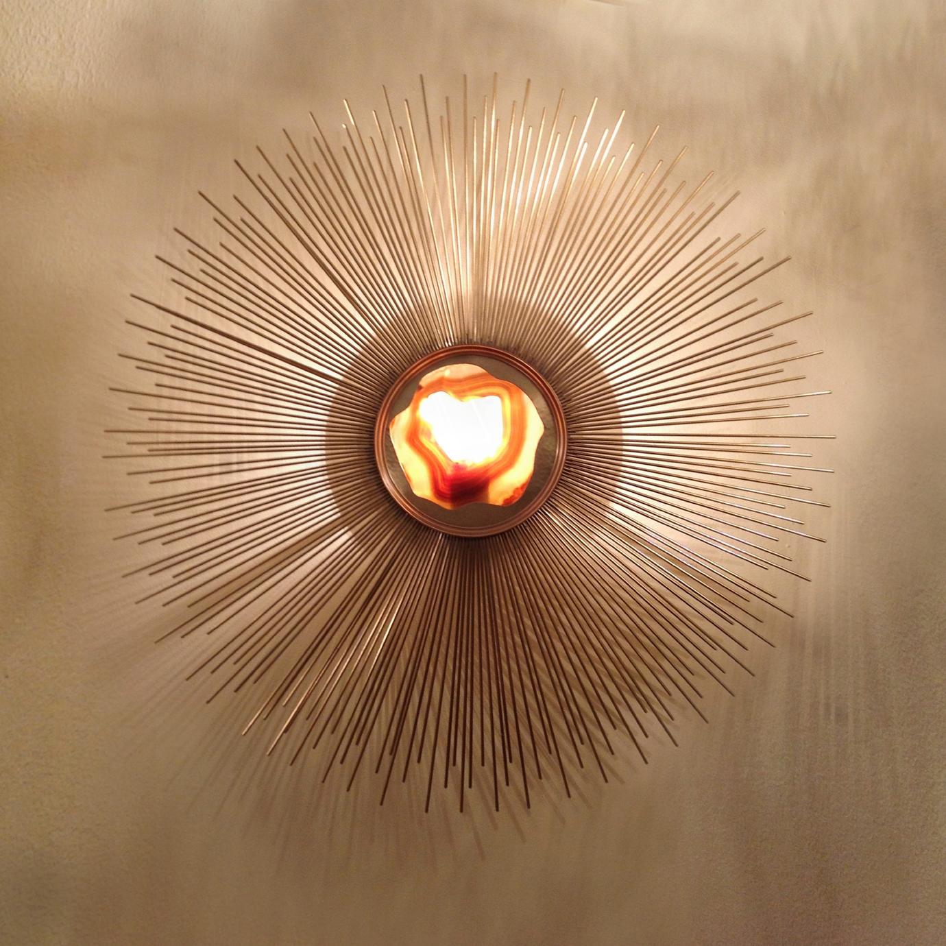 Tantalizing tones and exquisite patterns in the agate stones are cast onto rays of metal giving this sconce show stopping qualities. The hand selected agate stones come in a choice of colors and are thin enough to let the light trickle through,