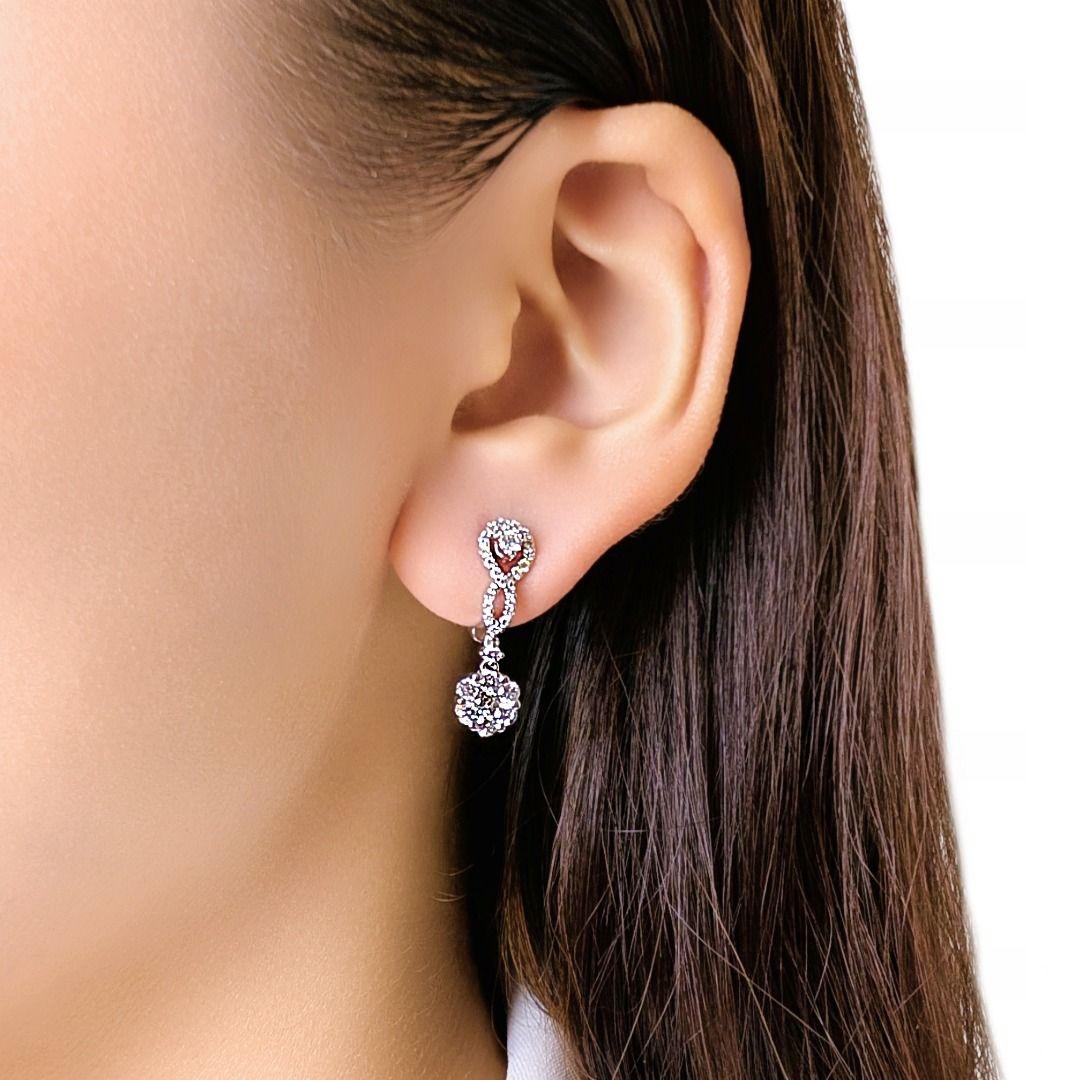 Ces élégantes boucles d'oreilles gouttes présentent 60 diamants ronds et brillants d'une valeur totale de 0,58 carat, de couleur G-H et de pureté VS, disposés dans une silhouette gracieuse qui mêle boucles, courbes d'inspiration marquise et