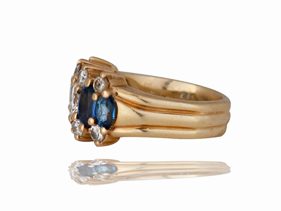 This vintage sapphire and diamond ring contains the following. This ring is Cast from 14 karat yellow gold and has one round brilliant diamond measuring 5.34 mm in the center. There are also 8 2.8 mm round brilliant diamond set in a offset four