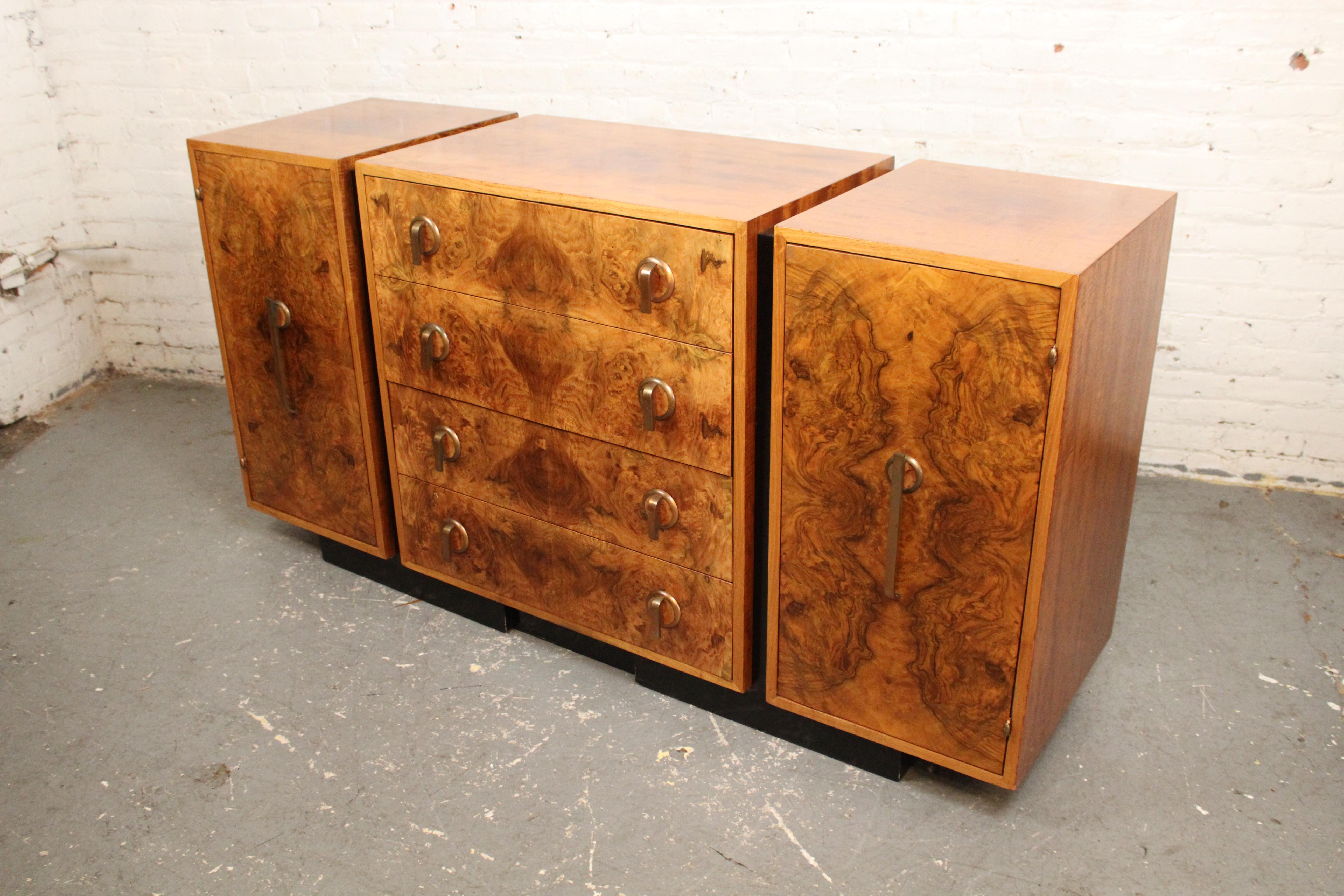 Ce superbe buffet est composé de bois d'érable ronceux et de ferrures en laiton. La base est noire pour donner un effet flottant à l'armoire. Quatre tiroirs et deux armoires offrent un grand espace de rangement pour le salon ou la chambre à