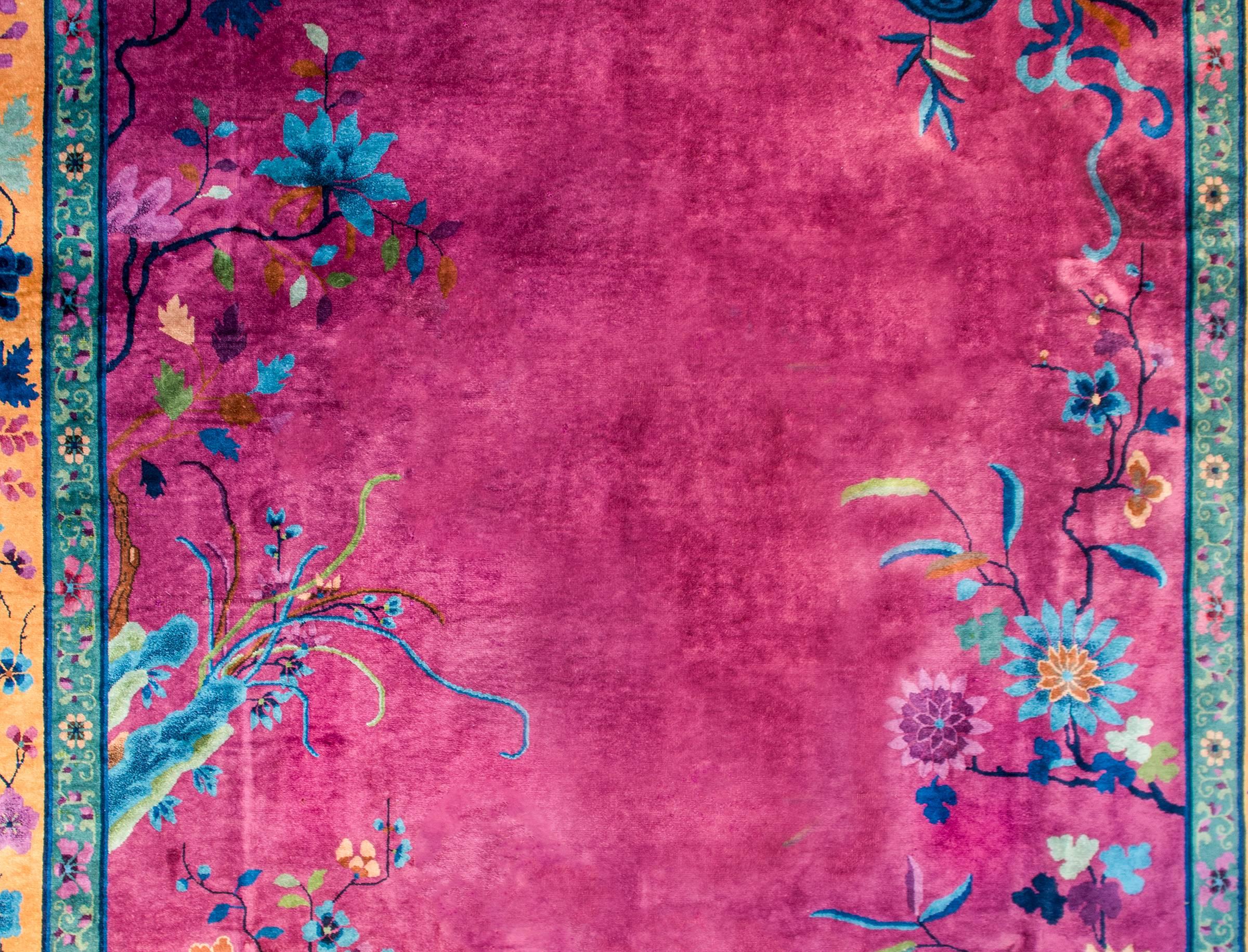 Wonderful early 20th century Chinese Art Deco rug with a brilliant fuchsia field surrounded by a thin turquoise border with a petite floral and vine pattern, and a wide peach colored border, also with a large-scale floral and vine pattern, and a