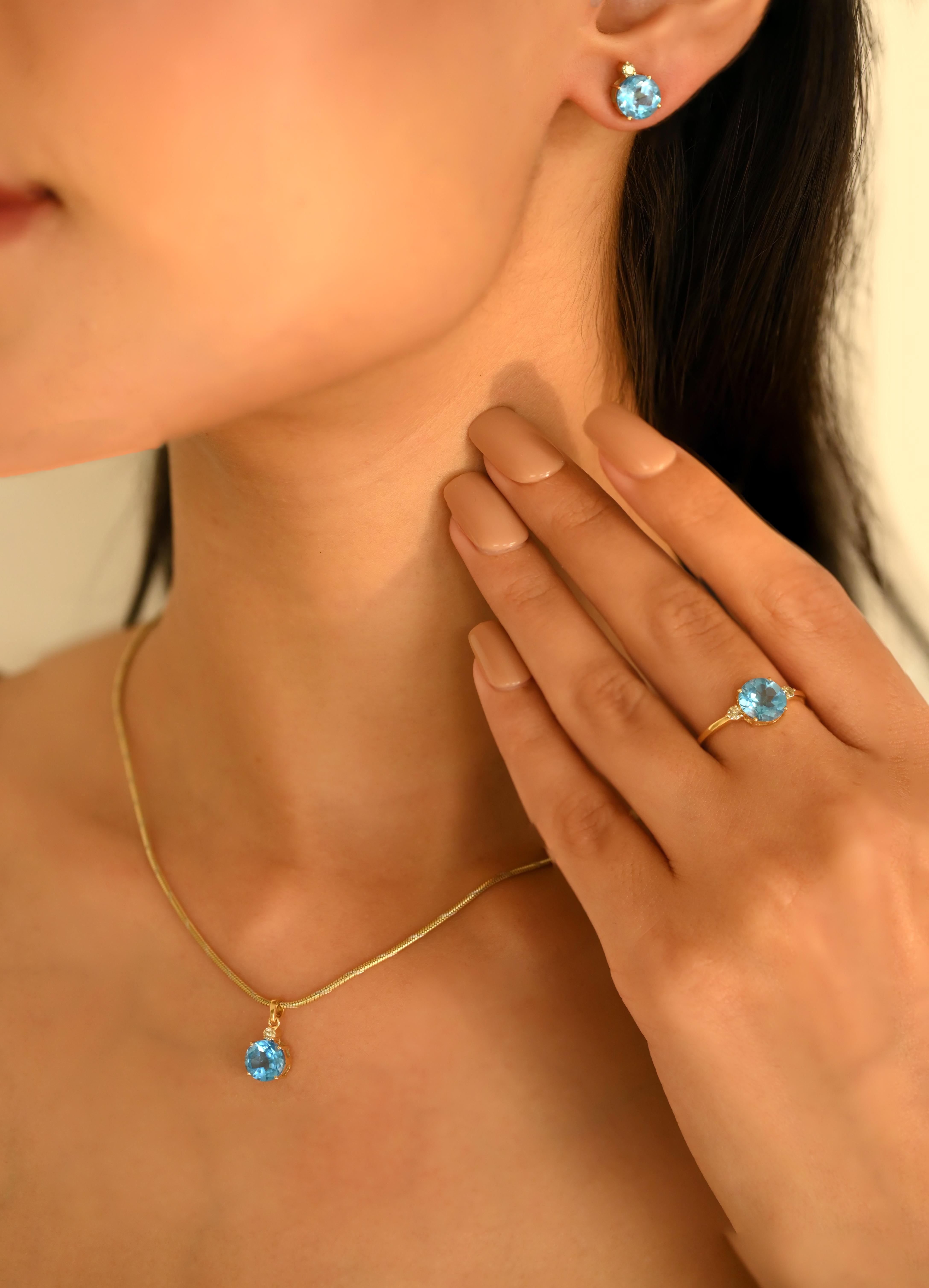 Brilliant Cut Blue Topaz Diamond Pendant Ring Earrings Set in 18K Gold studded with round cut blue topaz with round cut diamonds. This stunning piece of jewelry instantly elevates a casual look or dressy outfit. 
Blue topaz promotes truth and