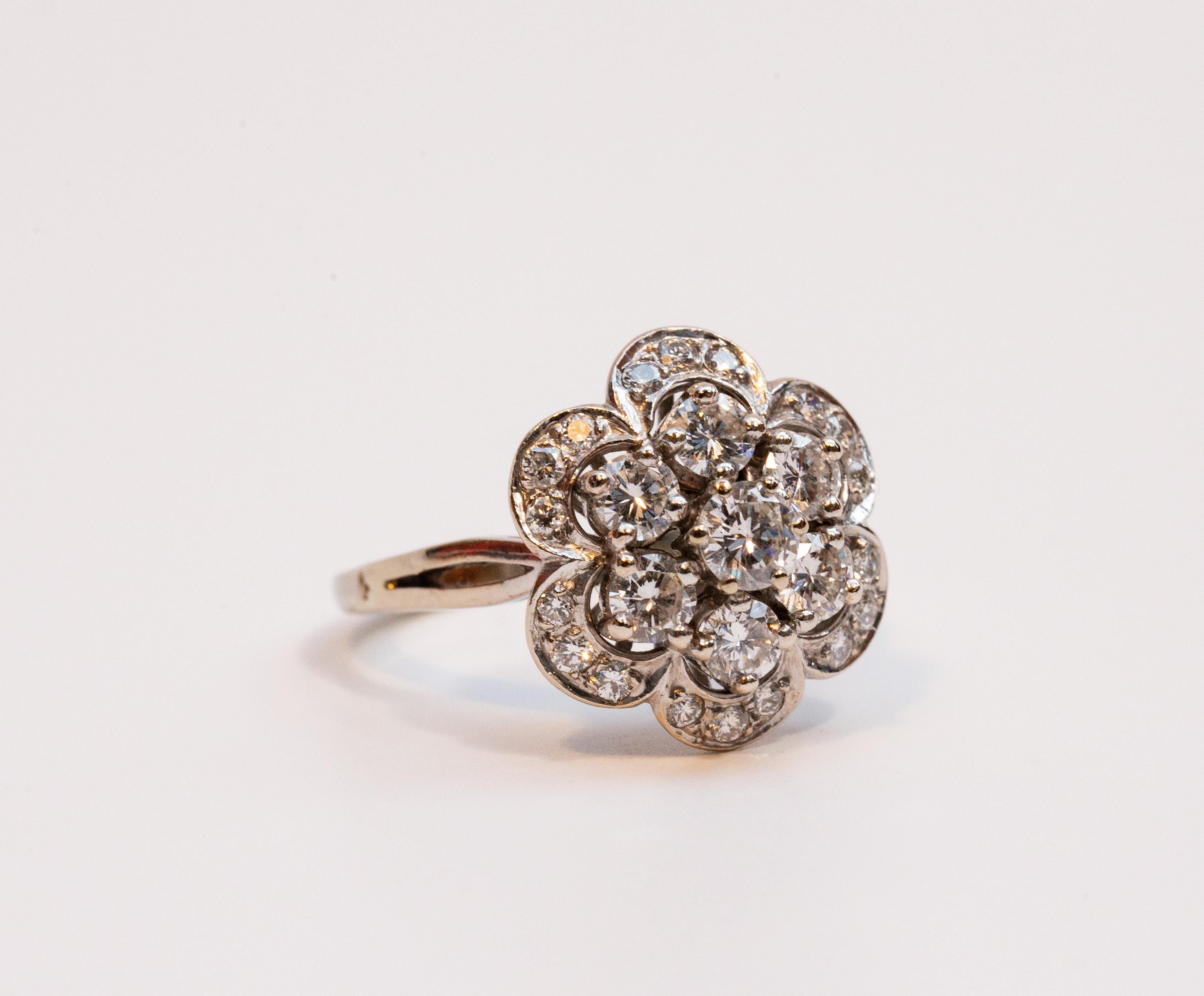 Bague vintage en or blanc 14 carats ornée de 25 diamants de taille brillant sertis dans une monture de grappes florales. La face de l'anneau se compose de 7 grands diamants centraux et de 18 petits diamants périphériques. Le diamant central a un