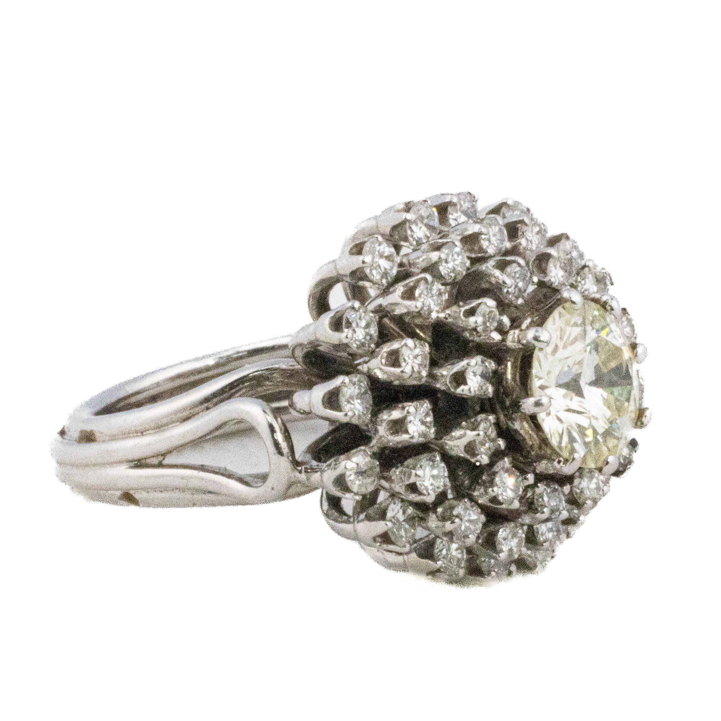 Diamant taillé en brillant Multi Halo Cluster

Description : Une éblouissante bague du milieu du siècle, réalisée en or blanc 18 carats, conçue avec un éclat radieux. En son centre repose un gros diamant rond taillé en brillant, entouré de deux