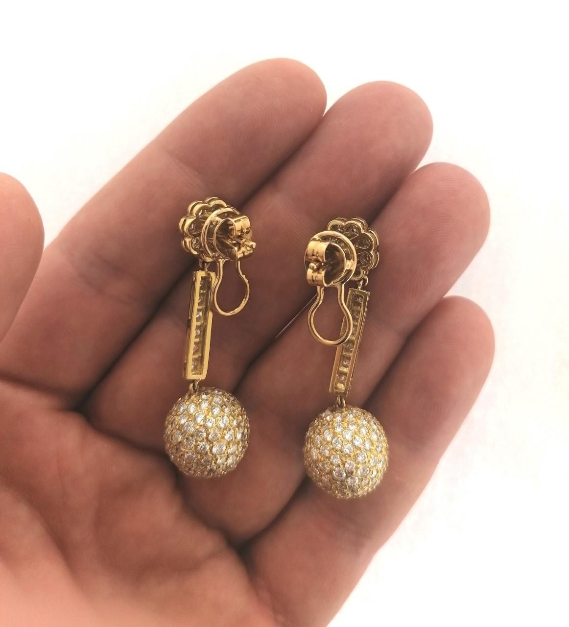 Original and colorful 18 karat yellow gold earrings with brilliants cut diamonds. They have three parts:
-A flower on the top, a bar in the middle and a ball down. All of them have movement. This earrings have a very secure closure that avoid the
