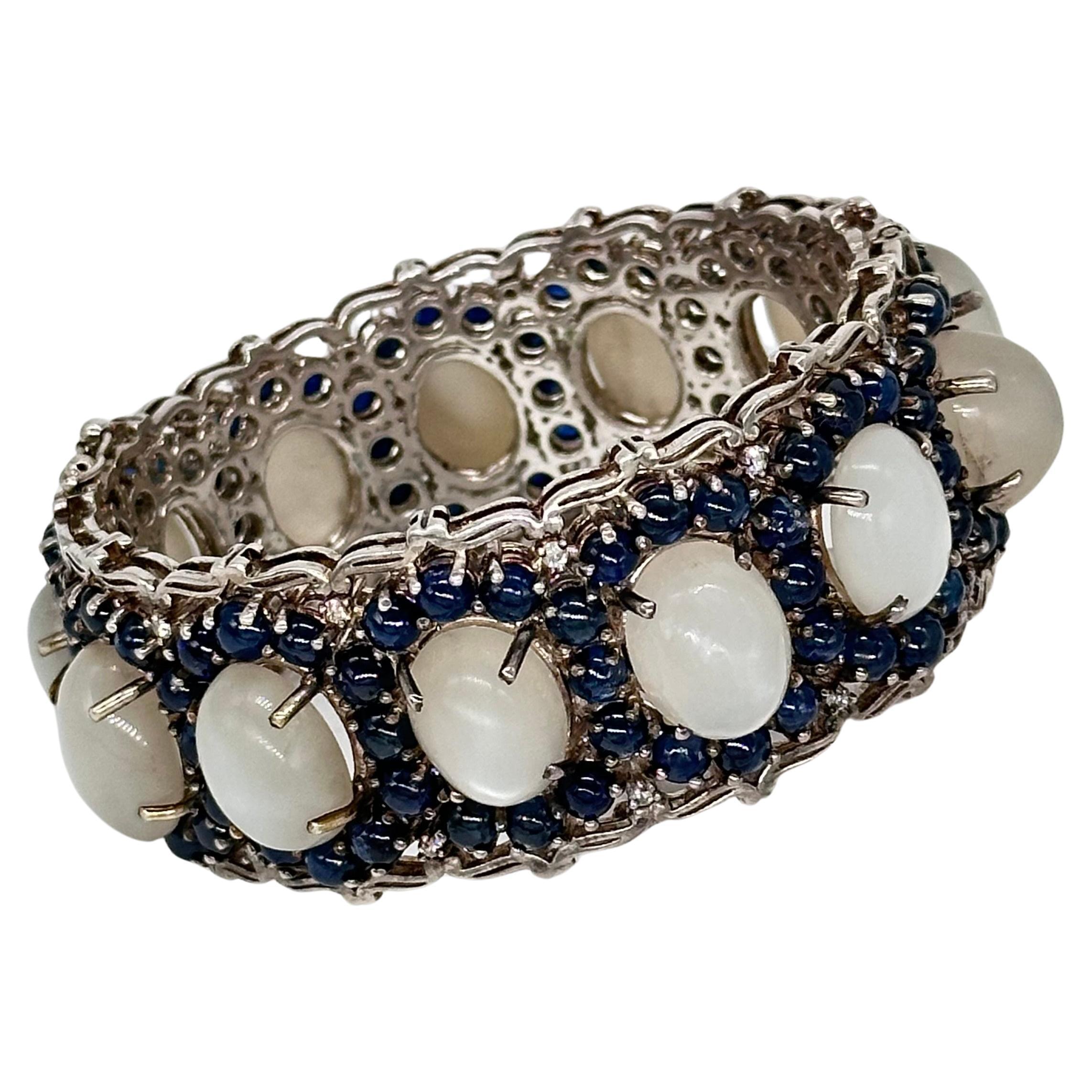 SKU-32PUJ-65/IU
Erleben Sie die Anziehungskraft zeitloser Eleganz mit diesem ovalen Armreif mit Scharnier, einer exquisiten Mischung aus Mondsteinen, blauen Saphiren und Diamanten im Brillantschliff. Das mit Präzision gefertigte Armband zeigt ein
